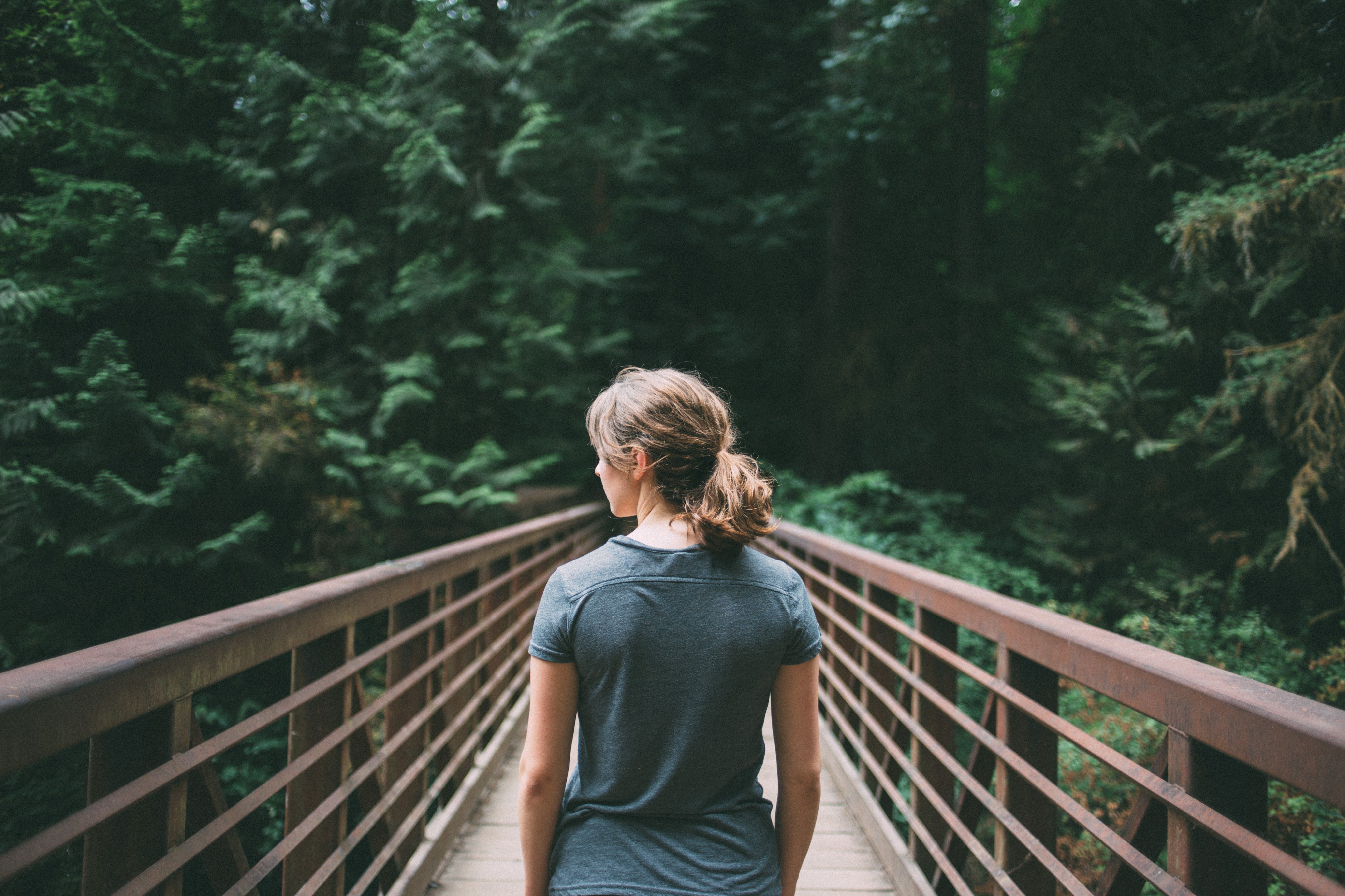 Woman on a bridge in a forest HD Wallpaper