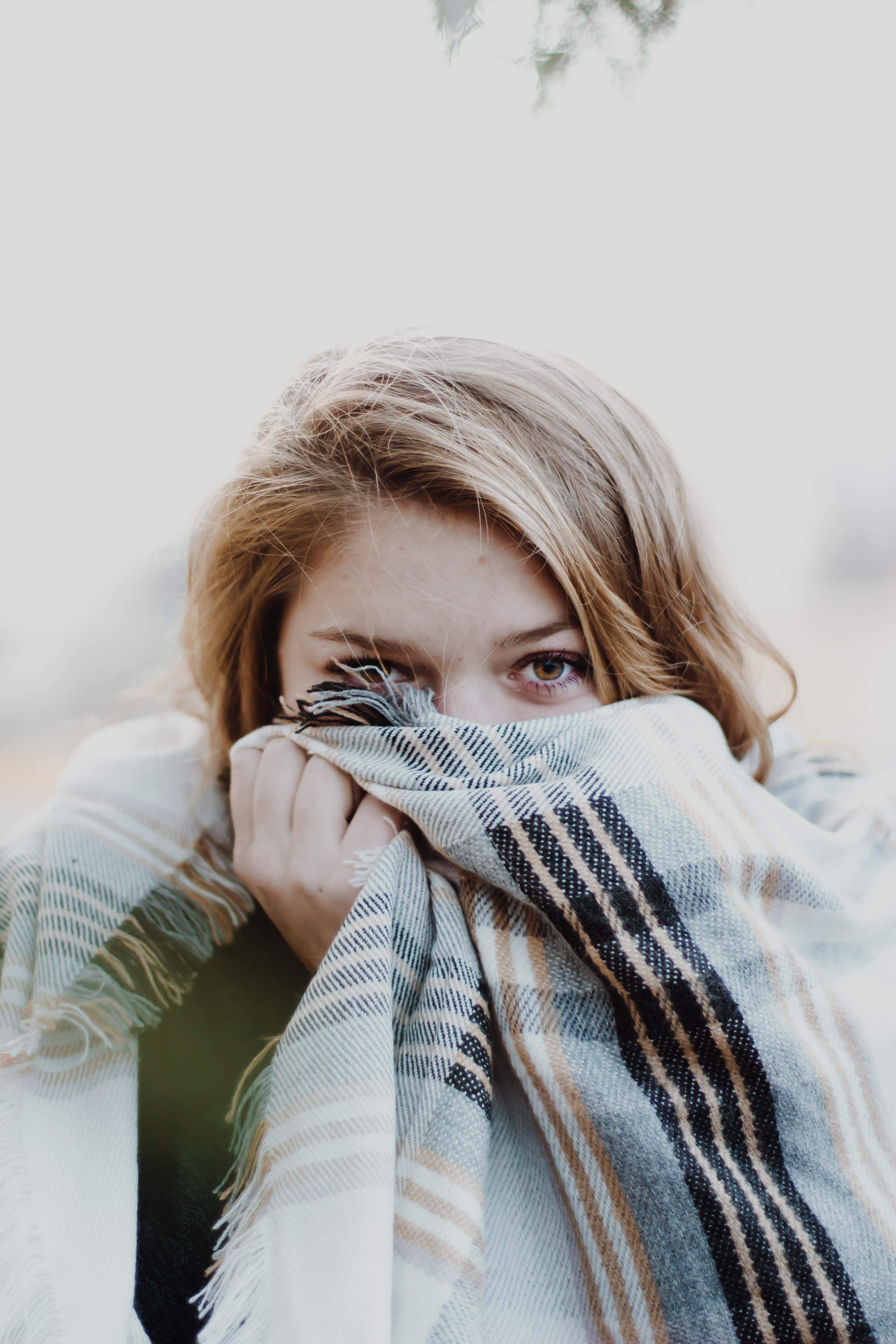 Woman with blonde hair covering face with blanket HD Wallpaper