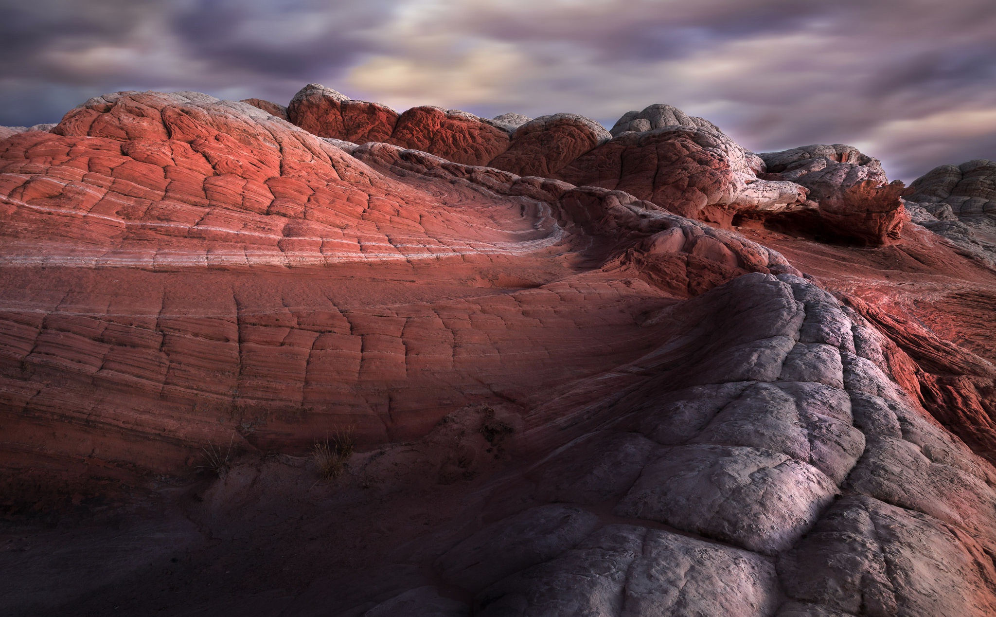 Red and white sandstone formations under a cloudy sky HD Wallpaper