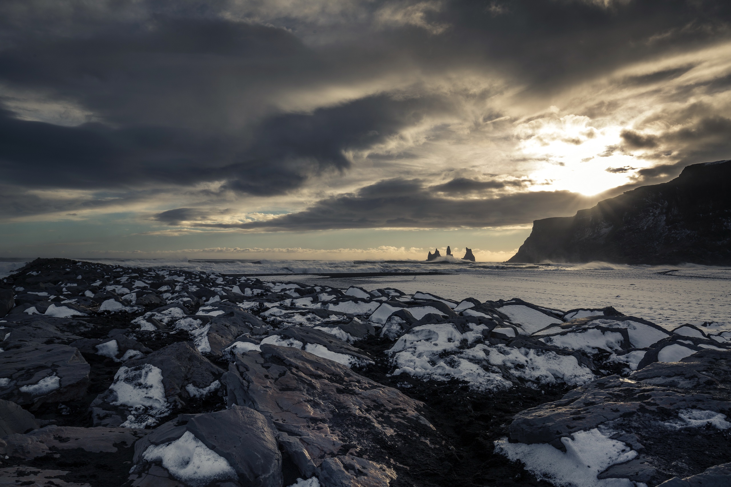 Rocky beach with snow and sea stacks at sunset HD Wallpaper