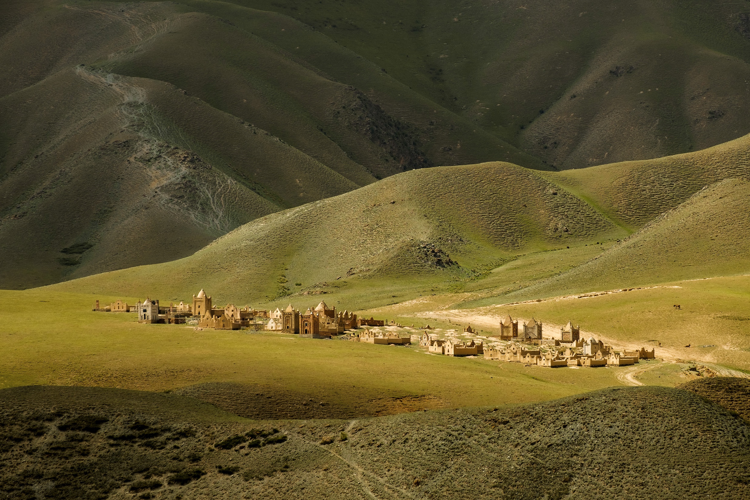 Ancient structures in a vast green mountain landscape HD Wallpaper