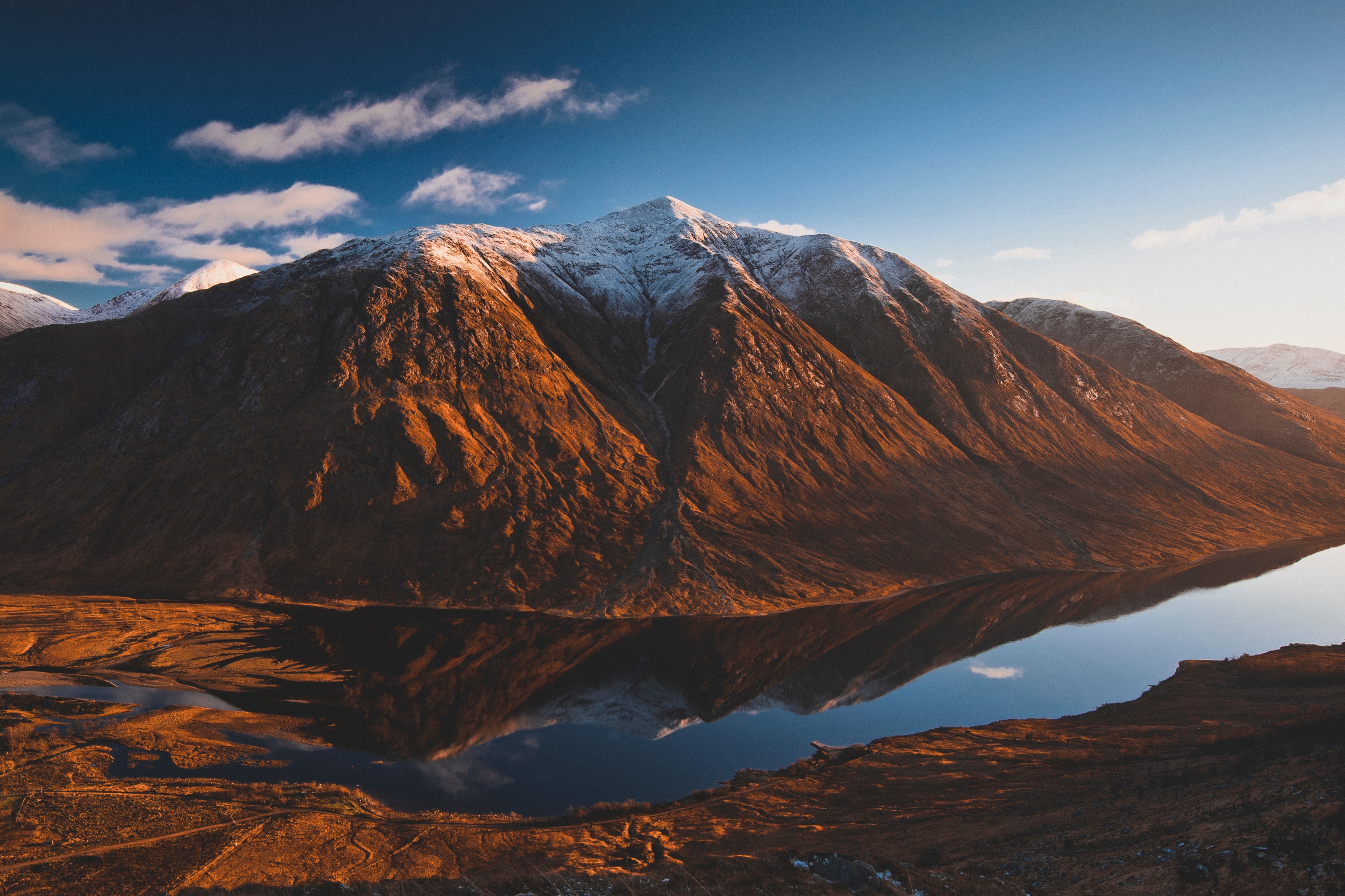 Snow-capped mountain reflected in a lake at sunset HD Wallpaper