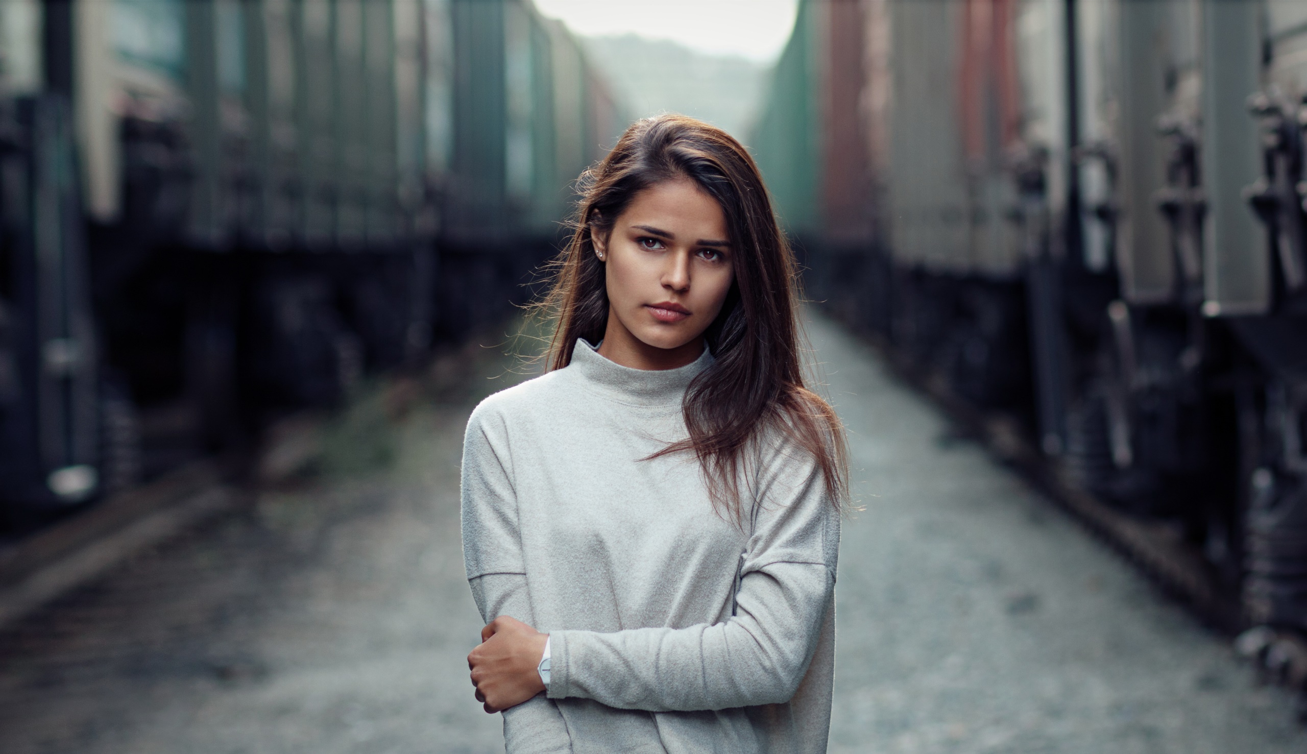 Woman standing between trains HD Wallpaper