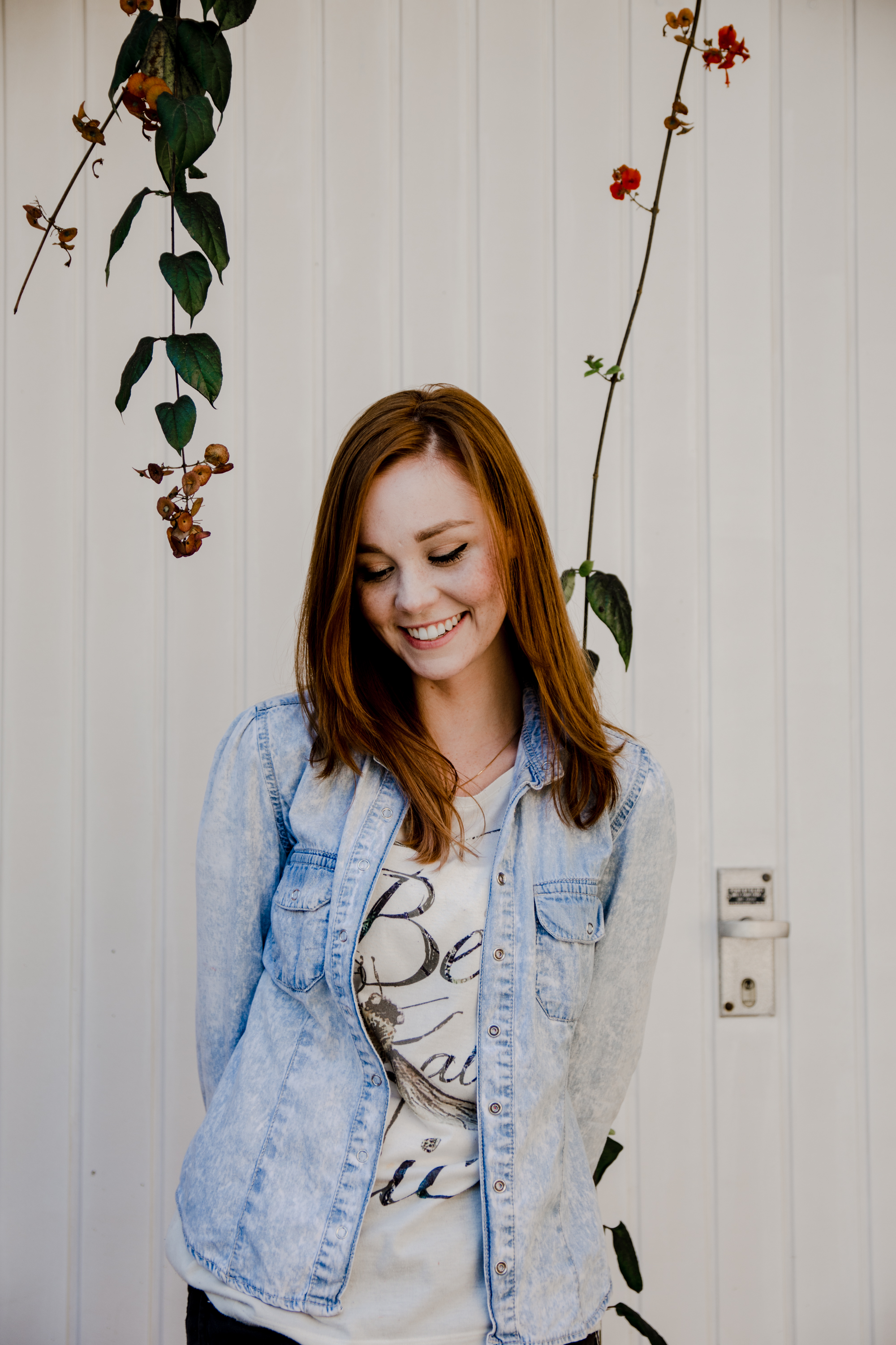 Redhead woman in denim jacket smiling outdoors HD Wallpaper