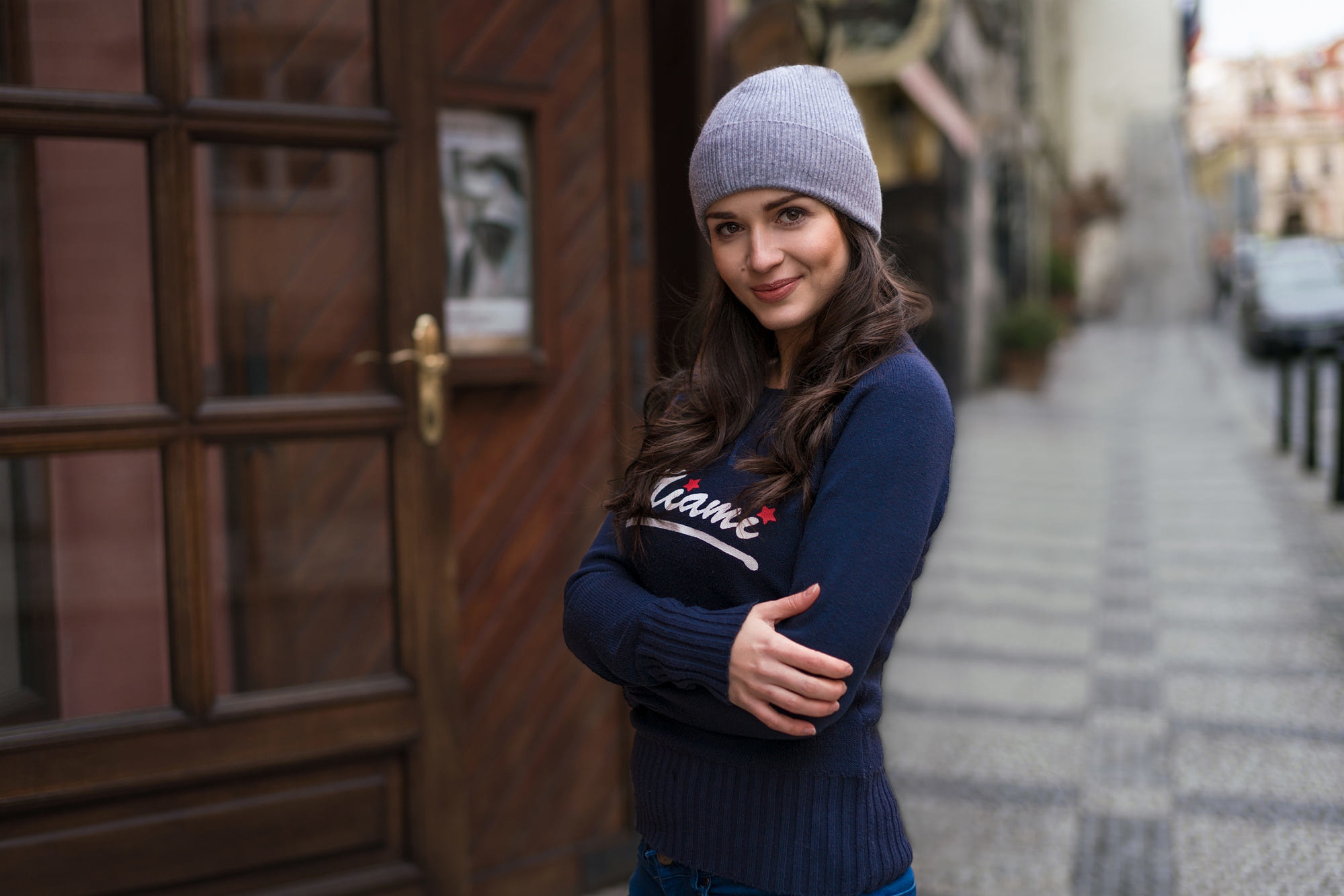 Woman wearing a hat and sweater on a street HD Wallpaper