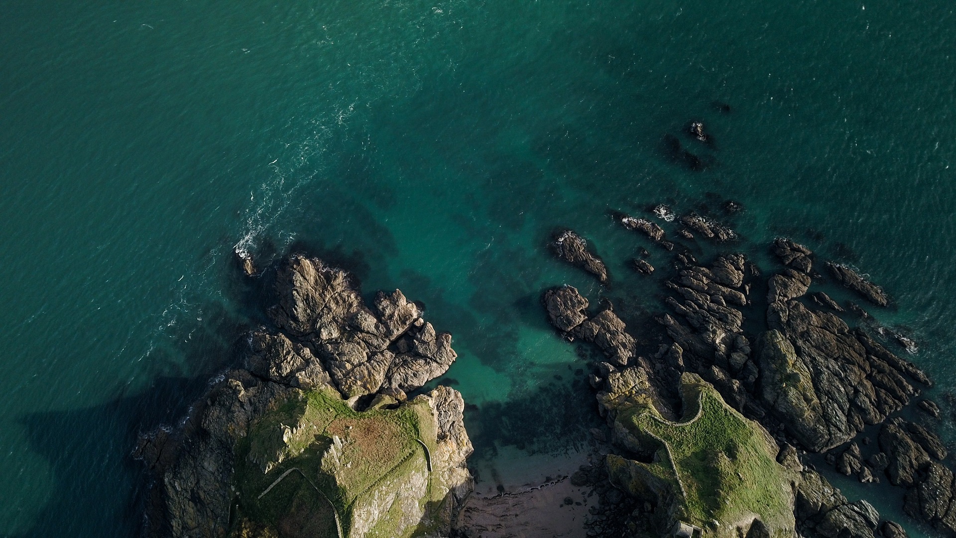 Aerial view of rocky coastline and turquoise sea HD Wallpaper