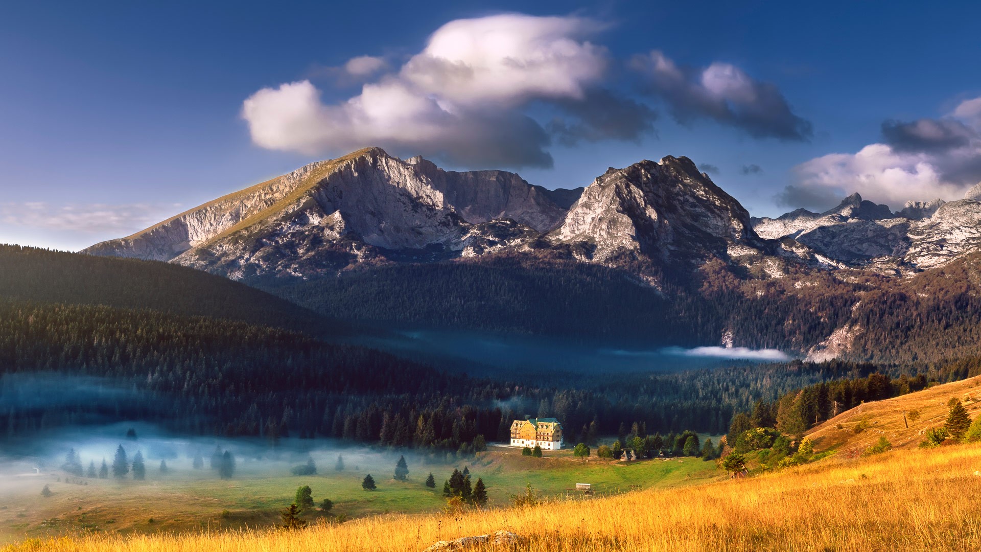 Mountain landscape with a building and mist HD Wallpaper