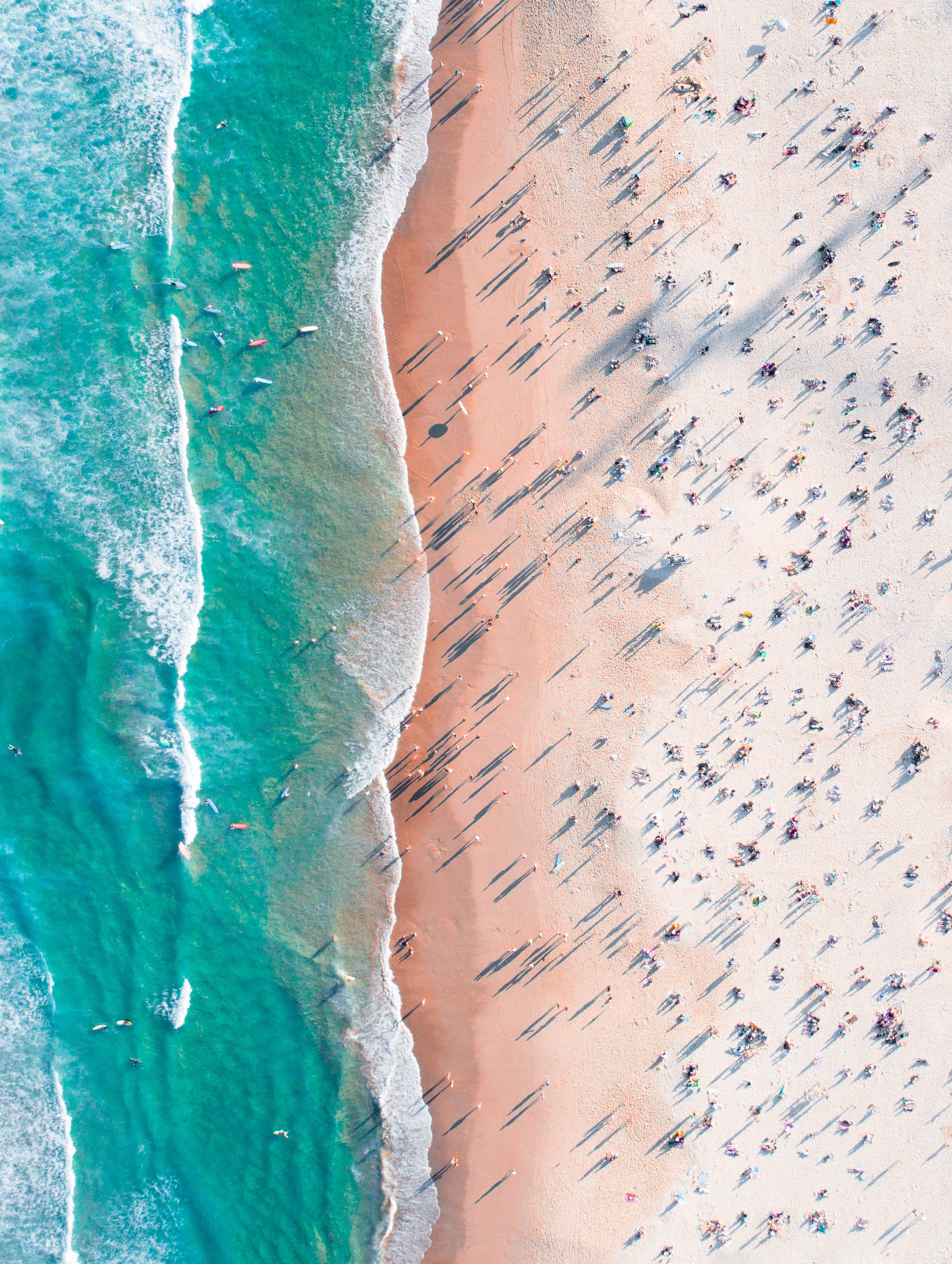 Aerial view of a crowded beach with turquoise waves HD Wallpaper