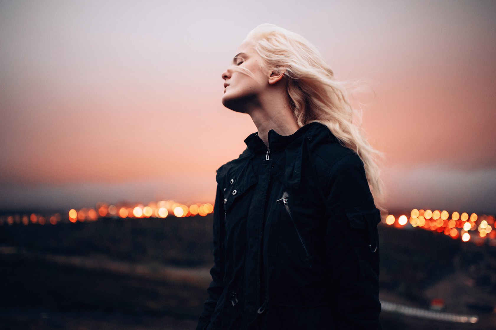 Woman with blonde hair in a black jacket at sunset HD Wallpaper