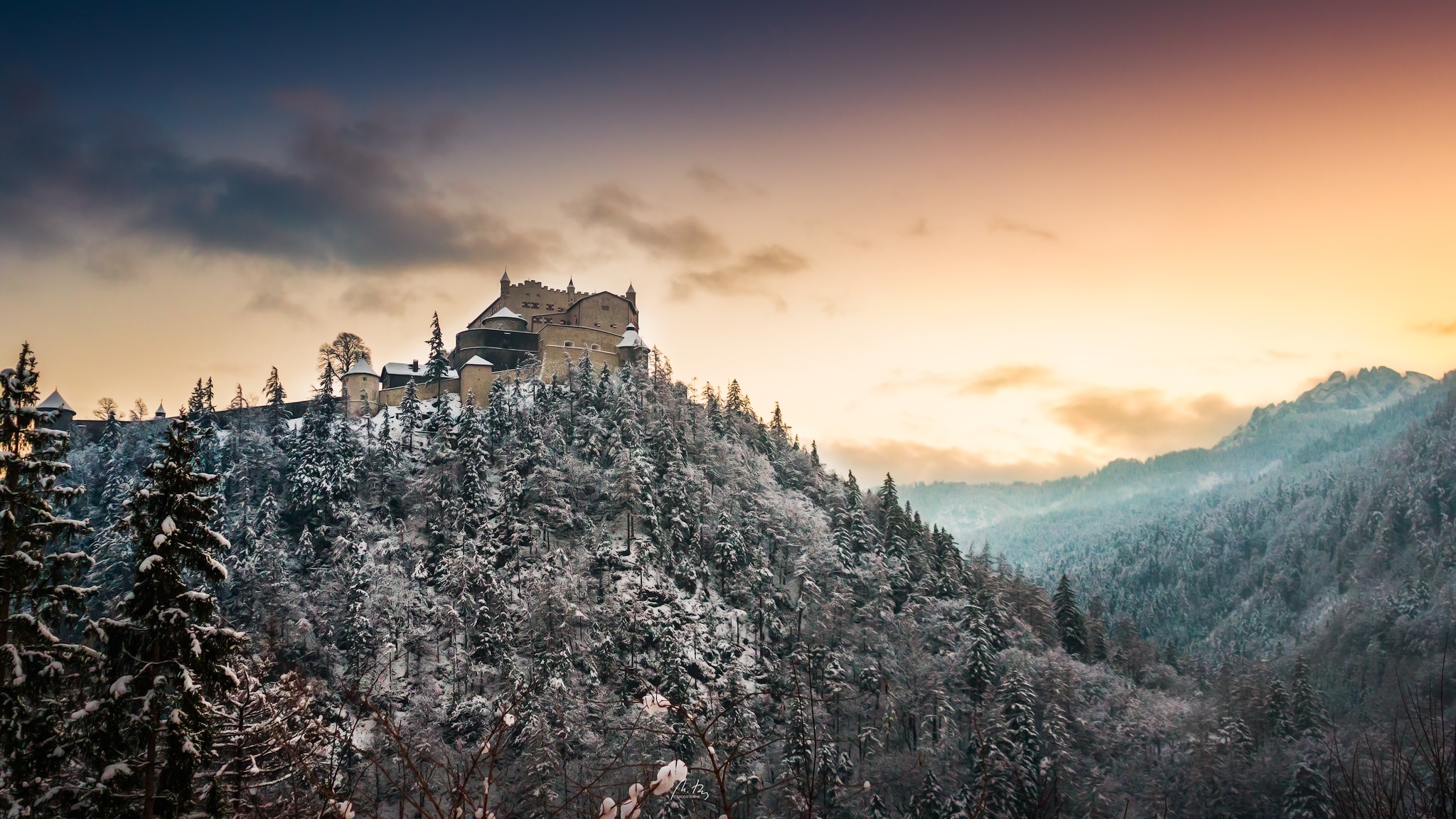 Castle on a snow-covered mountain with forest and sunset sky HD Wallpaper