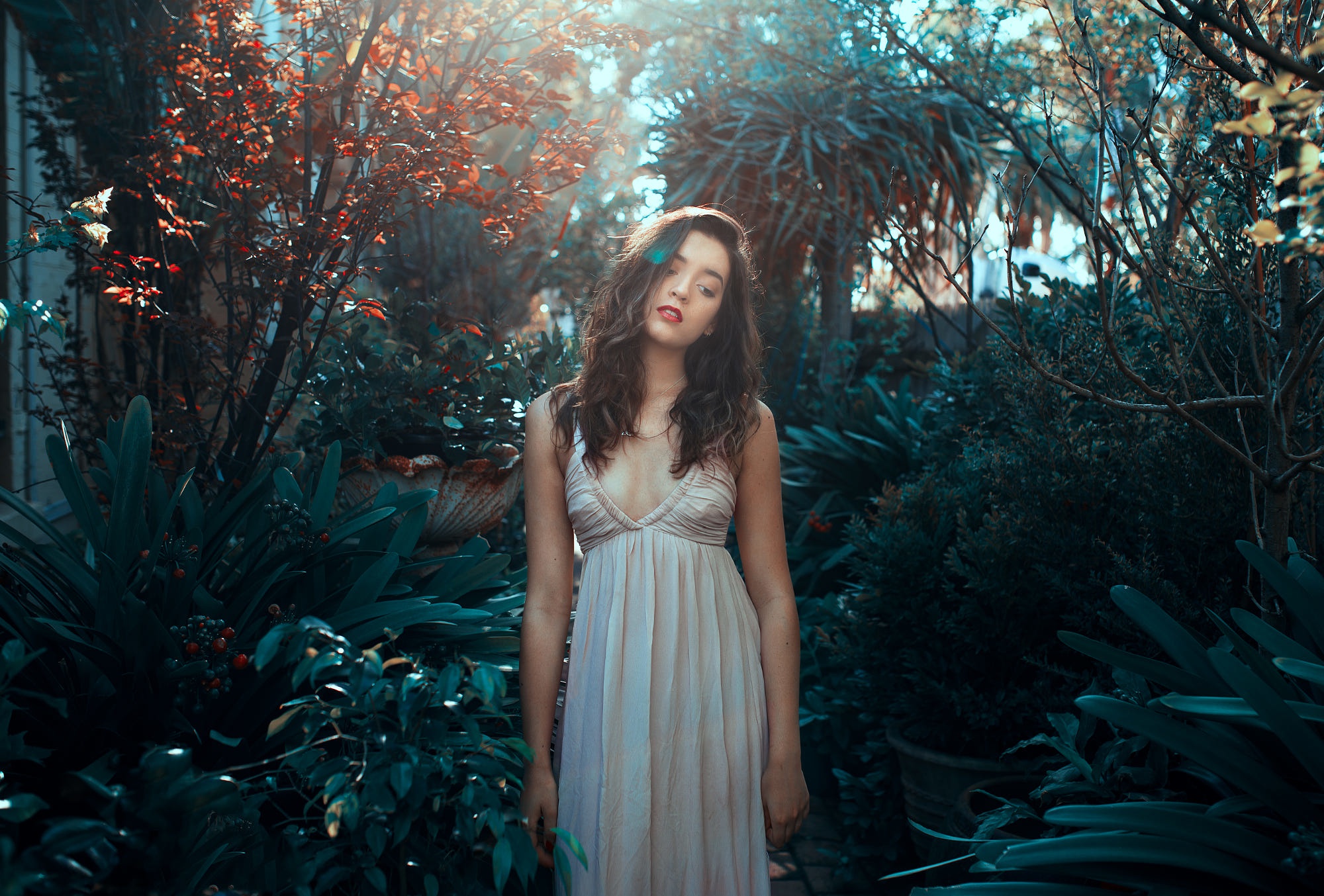 Woman in a light dress standing in a garden HD Wallpaper