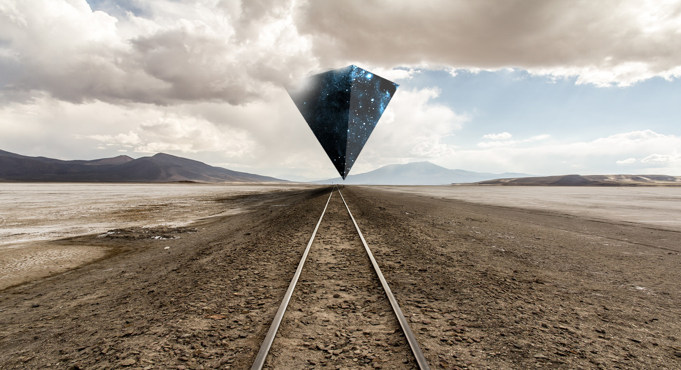 Pyramid floating over desert railway tracks HD Wallpaper