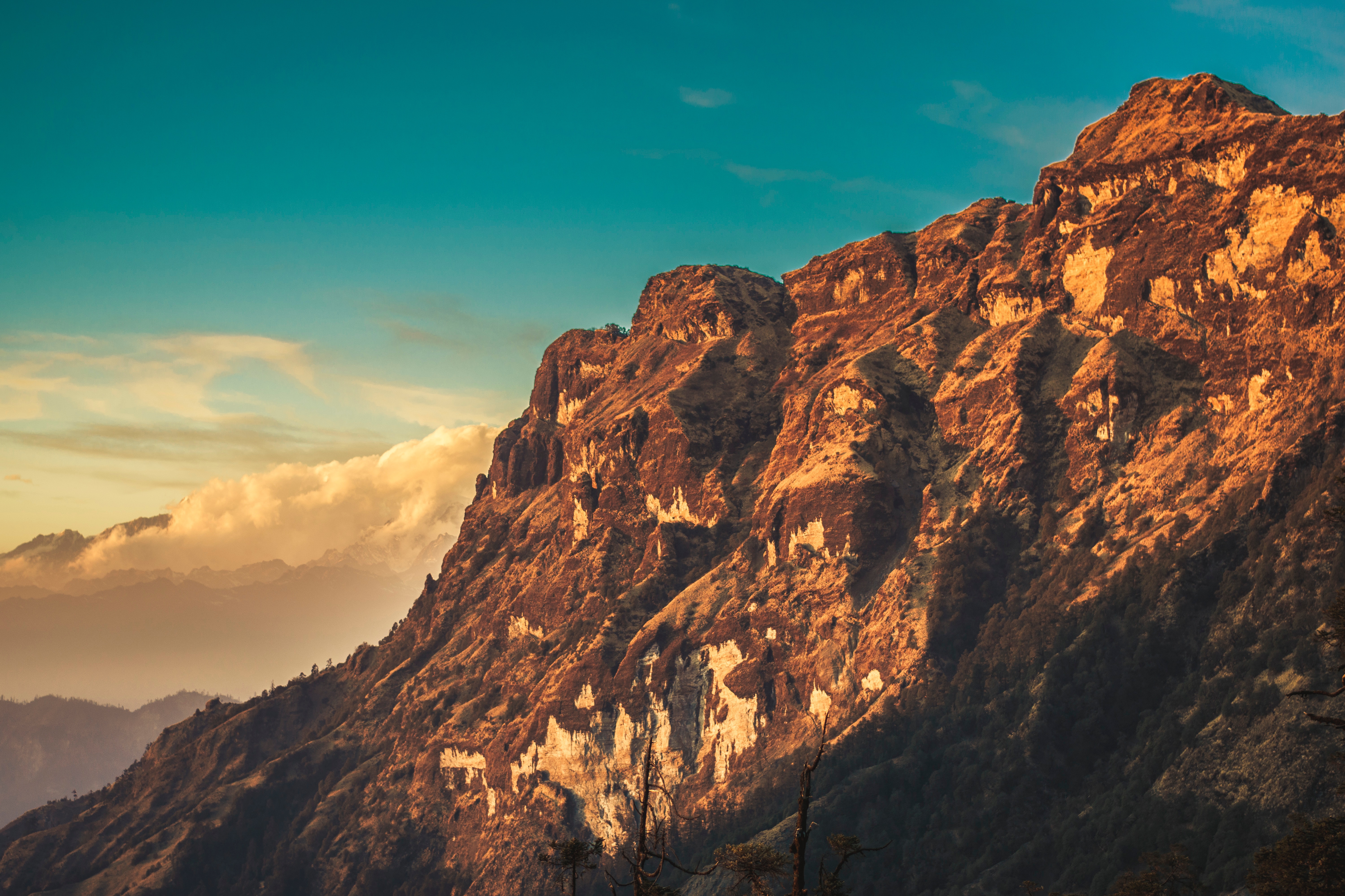 Golden mountain range under a blue sky HD Wallpaper
