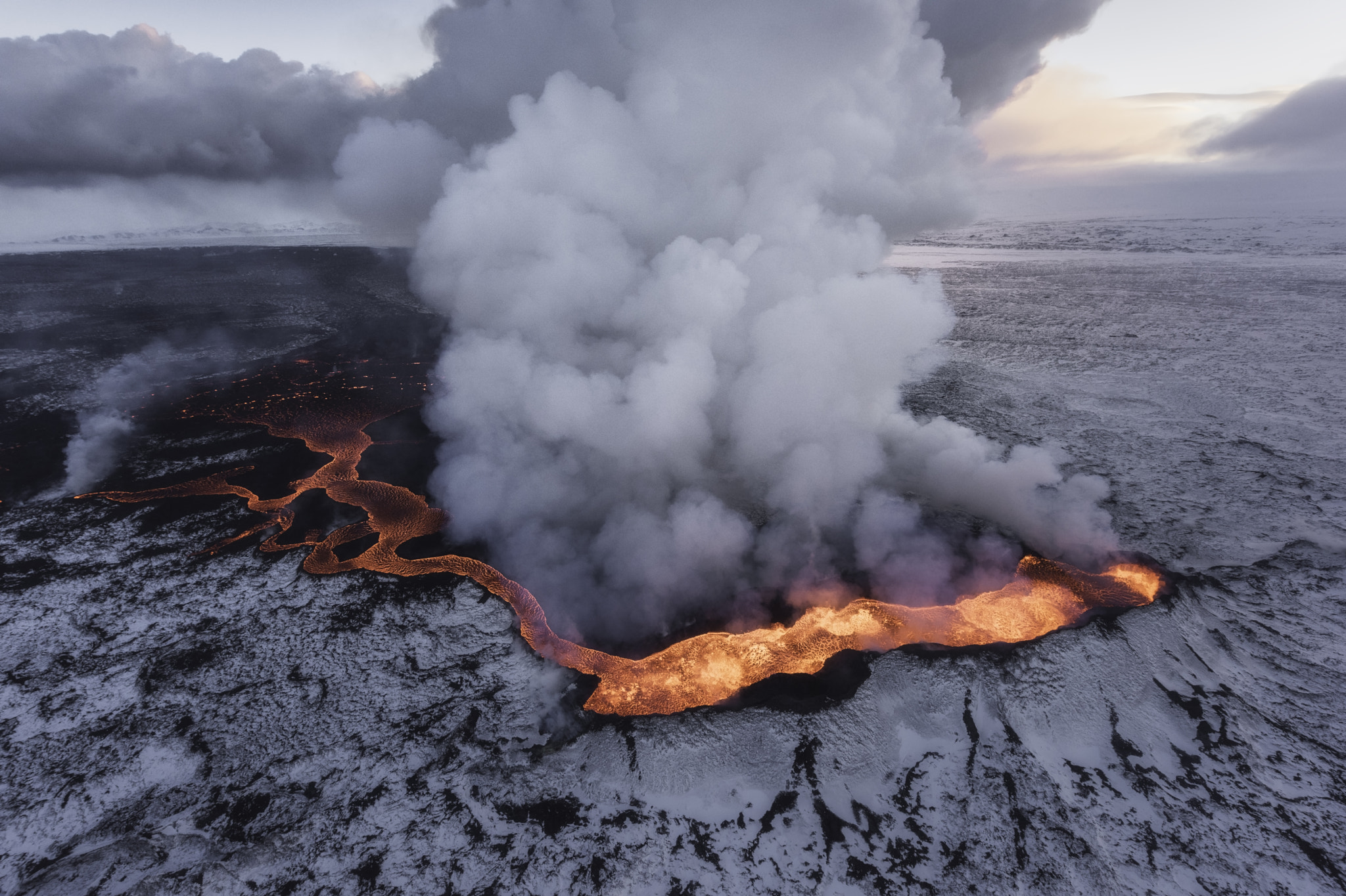 Lava flow in Iceland with snow and smoke HD Wallpaper