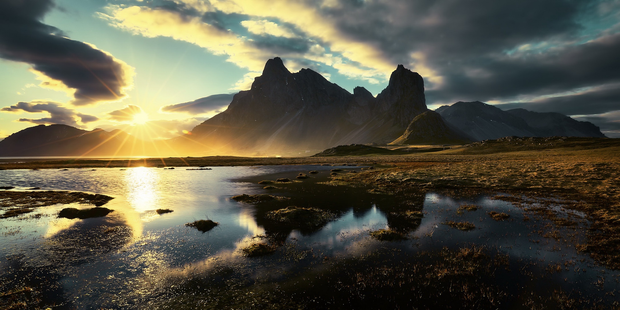 Sunset over mountains and water HD Wallpaper
