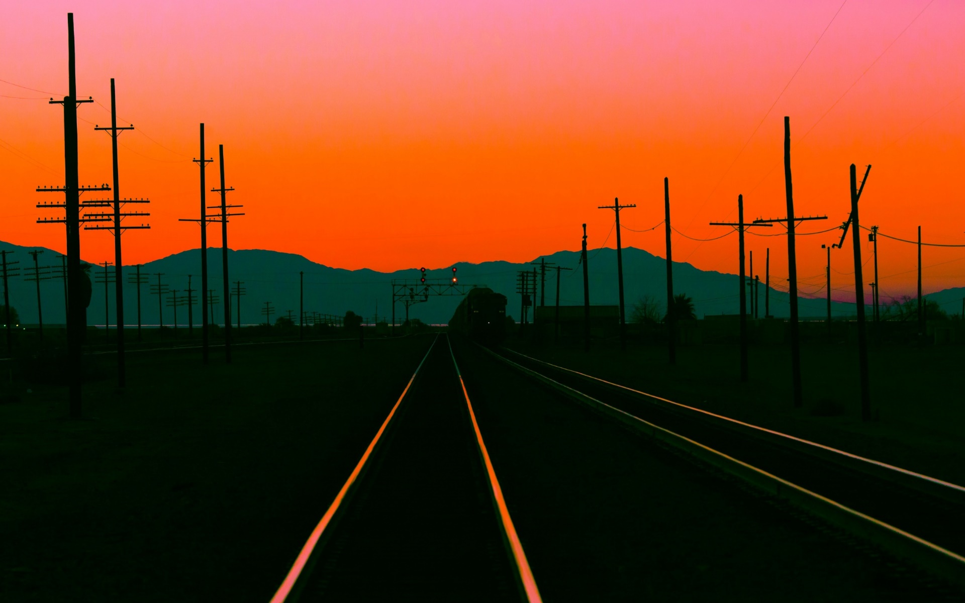 Railway tracks at sunset with mountains and power lines HD Wallpaper