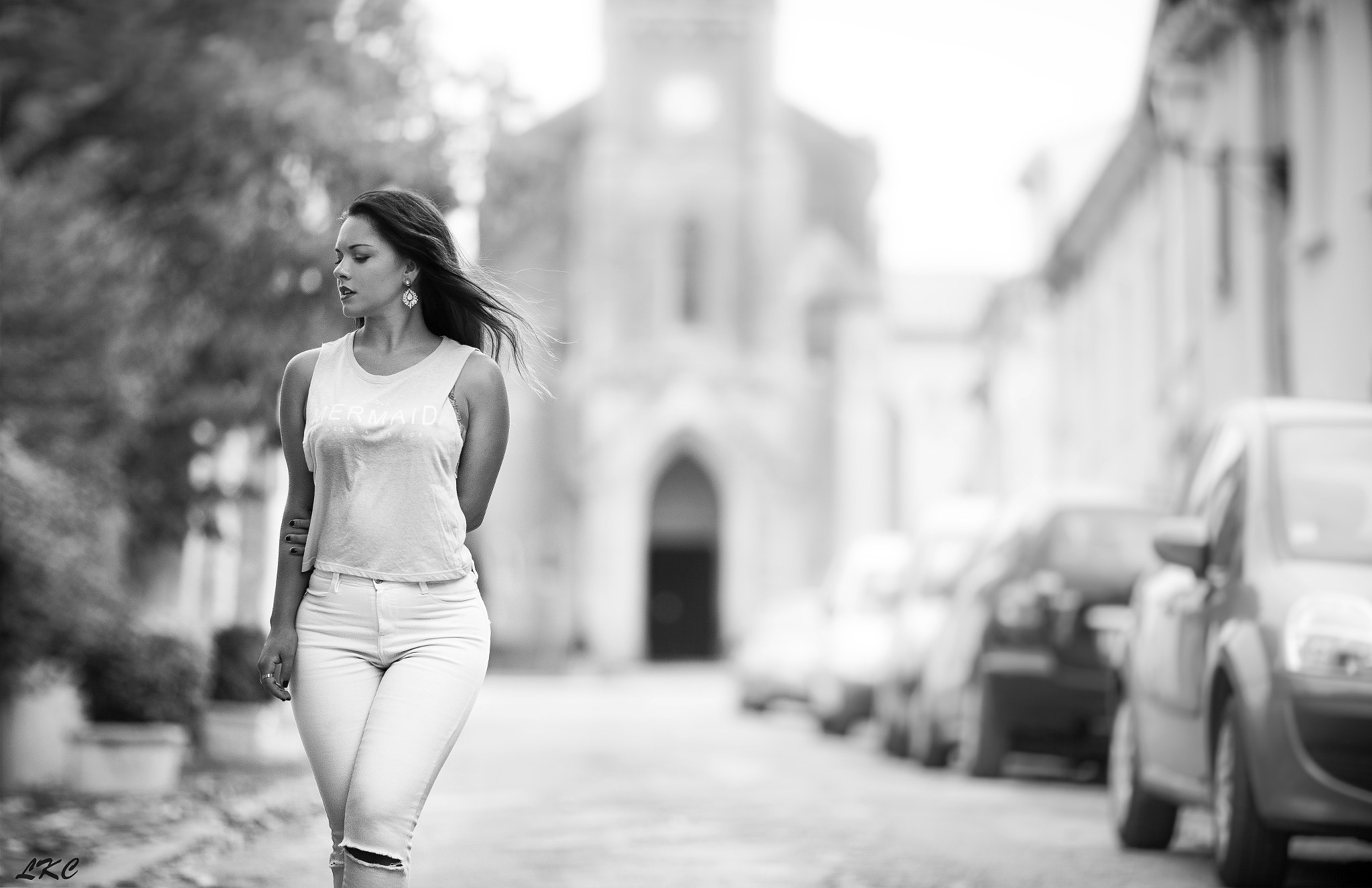 Woman in torn jeans walking down a street HD Wallpaper