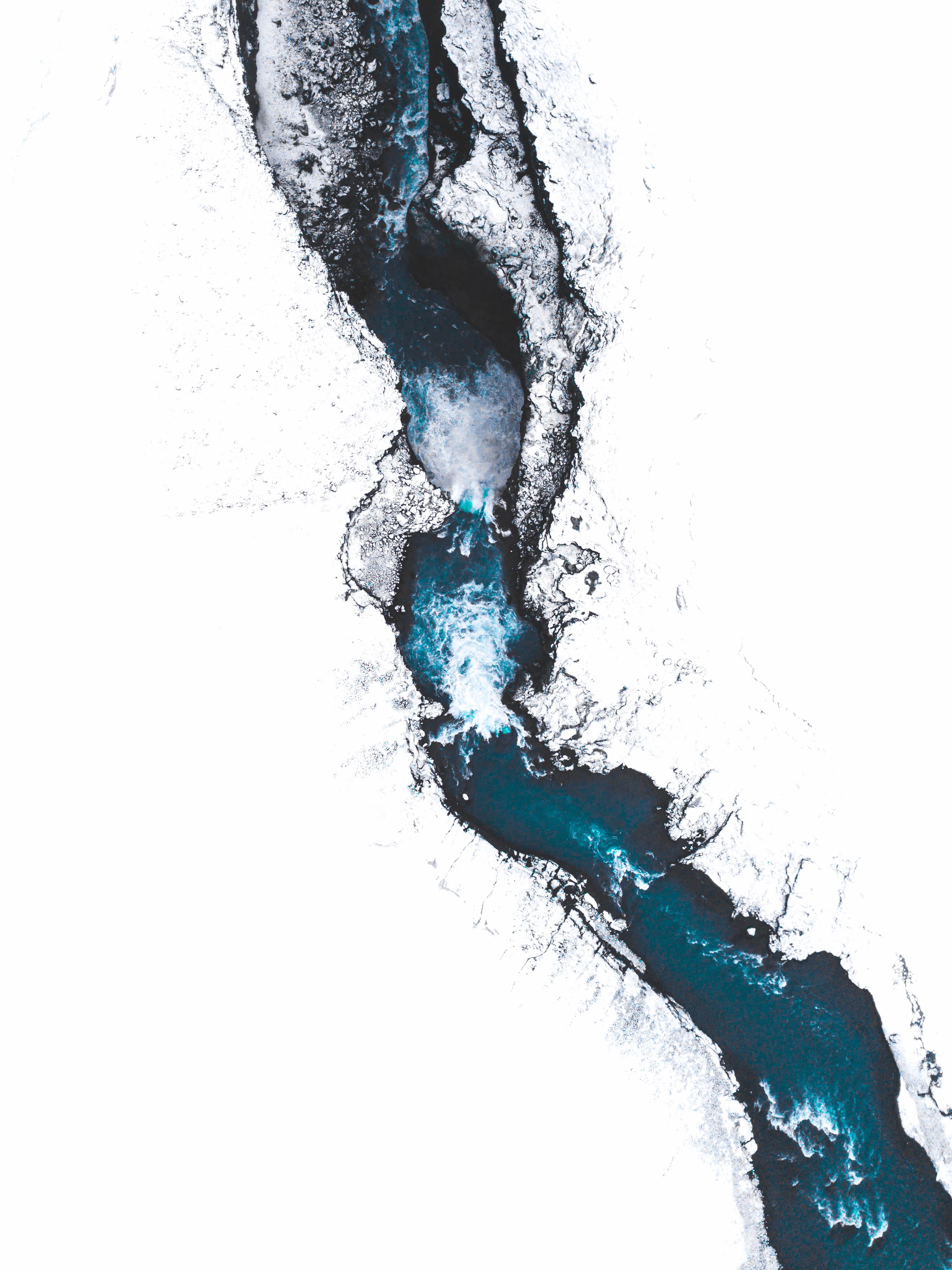 Aerial view of a river flowing through snow in Iceland HD Wallpaper