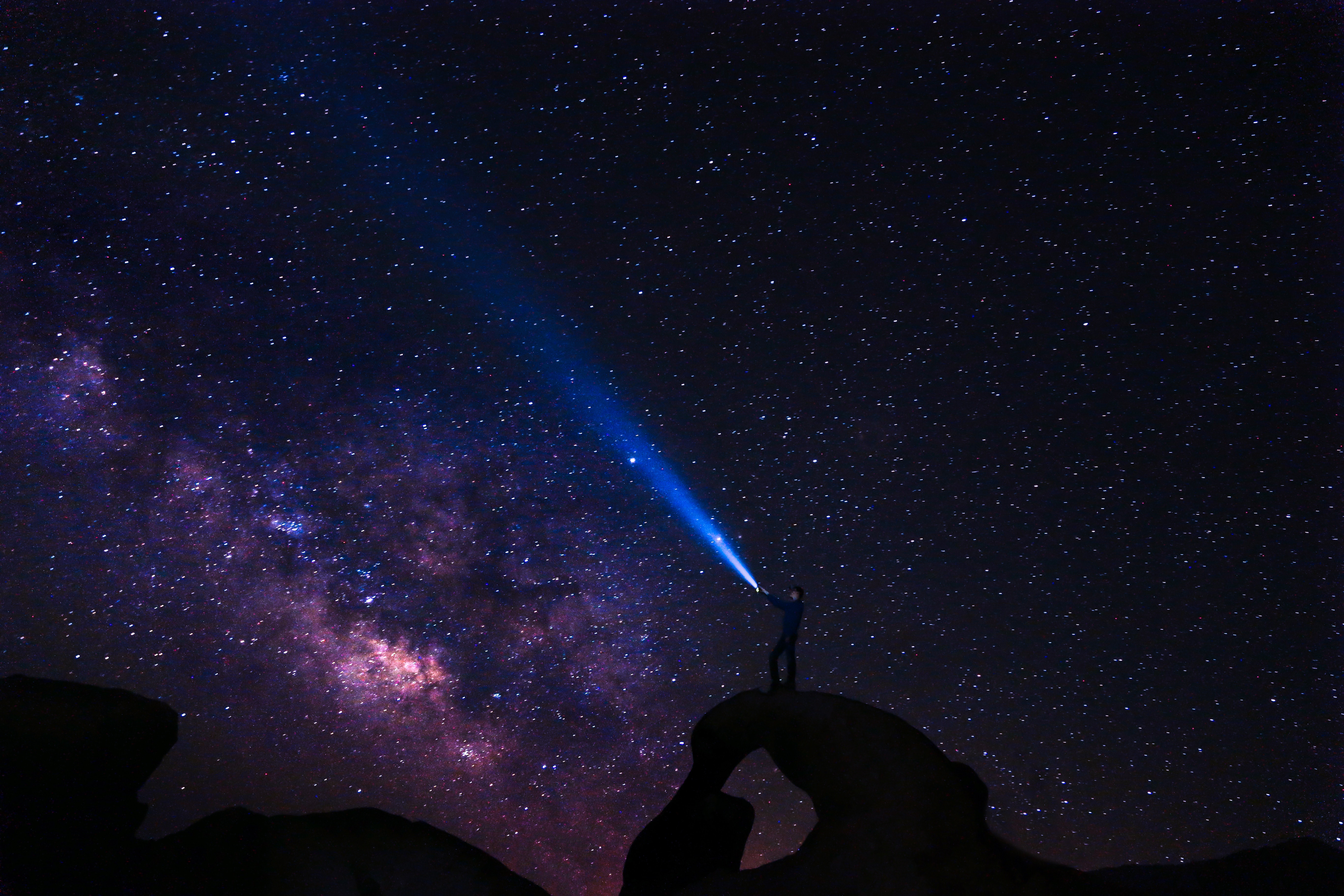 Person with flashlight under the Milky Way HD Wallpaper