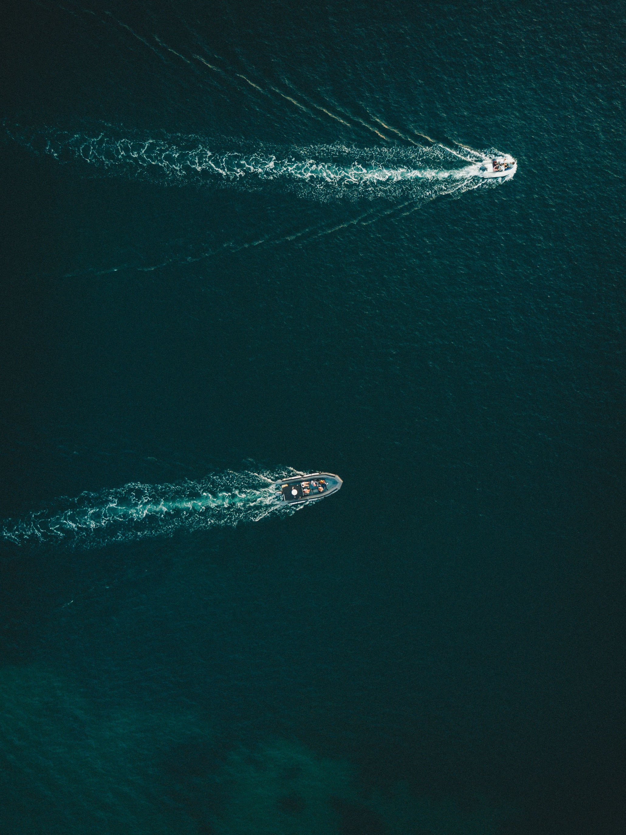 Two boats sailing on a dark blue ocean HD Wallpaper