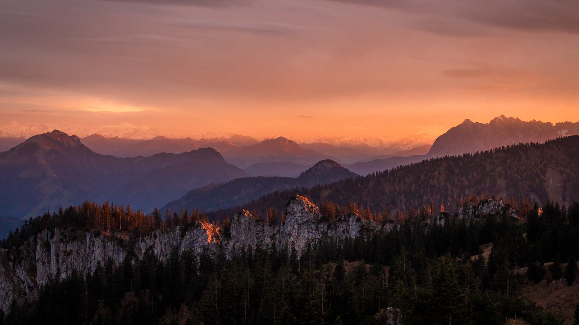 Mountain range at sunset with forest and clouds HD Wallpaper