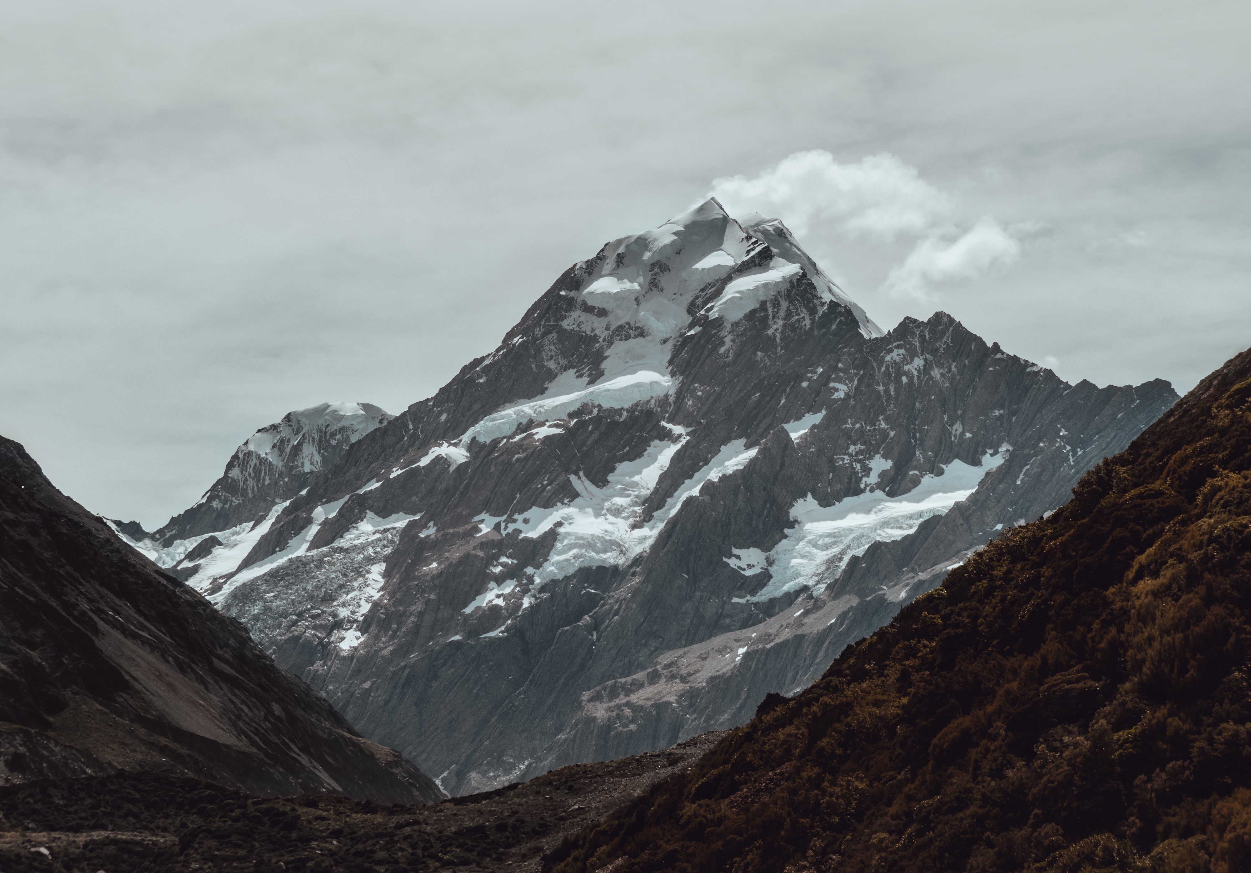 Snow-capped mountains under a cloudy sky HD Wallpaper