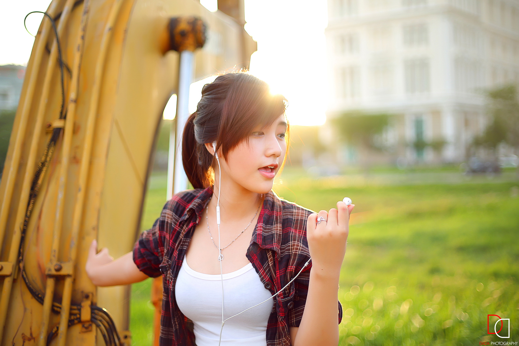 Asian woman with earphones near excavator HD Wallpaper