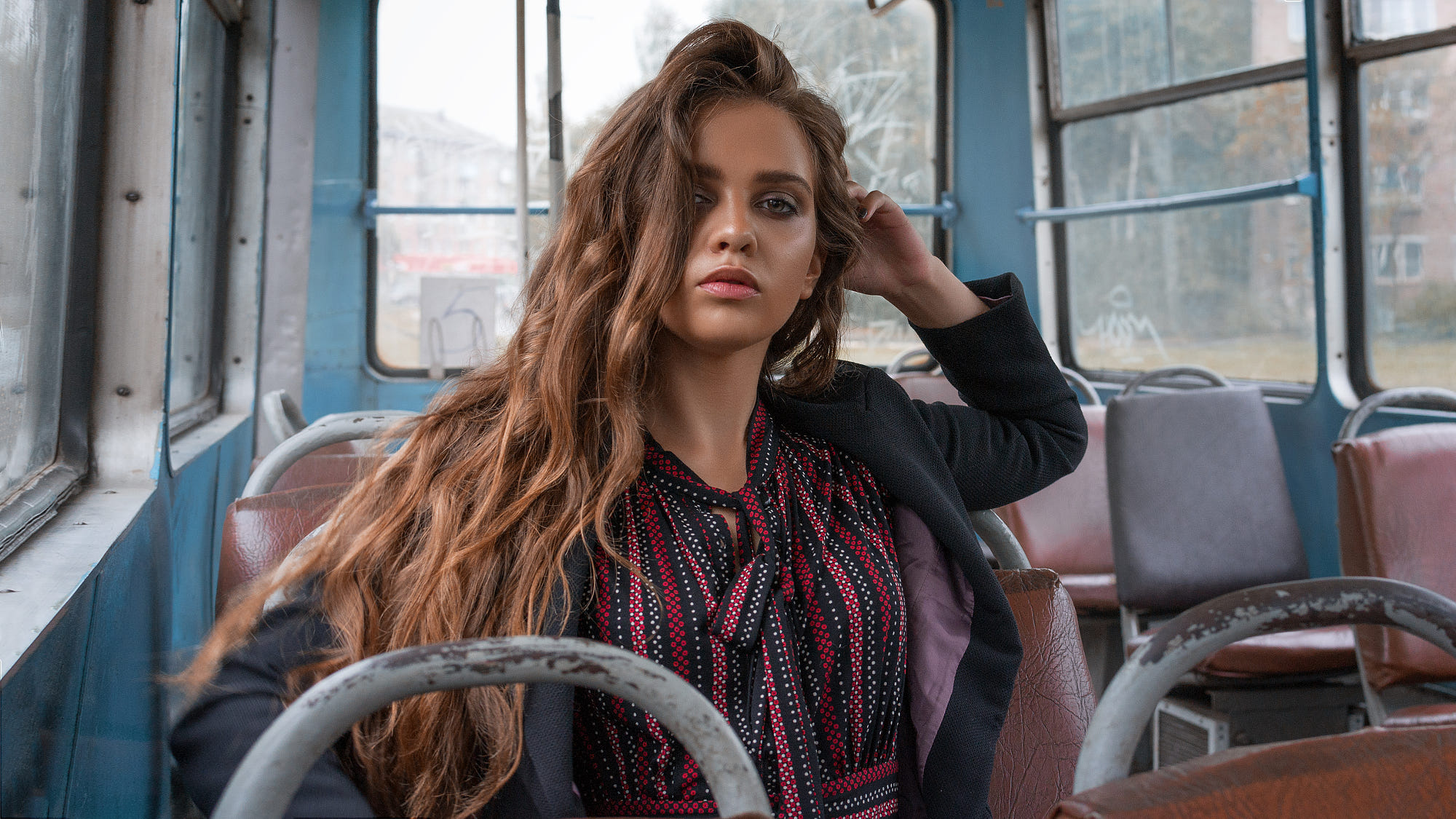 Woman with wavy brown hair sitting in a bus HD Wallpaper