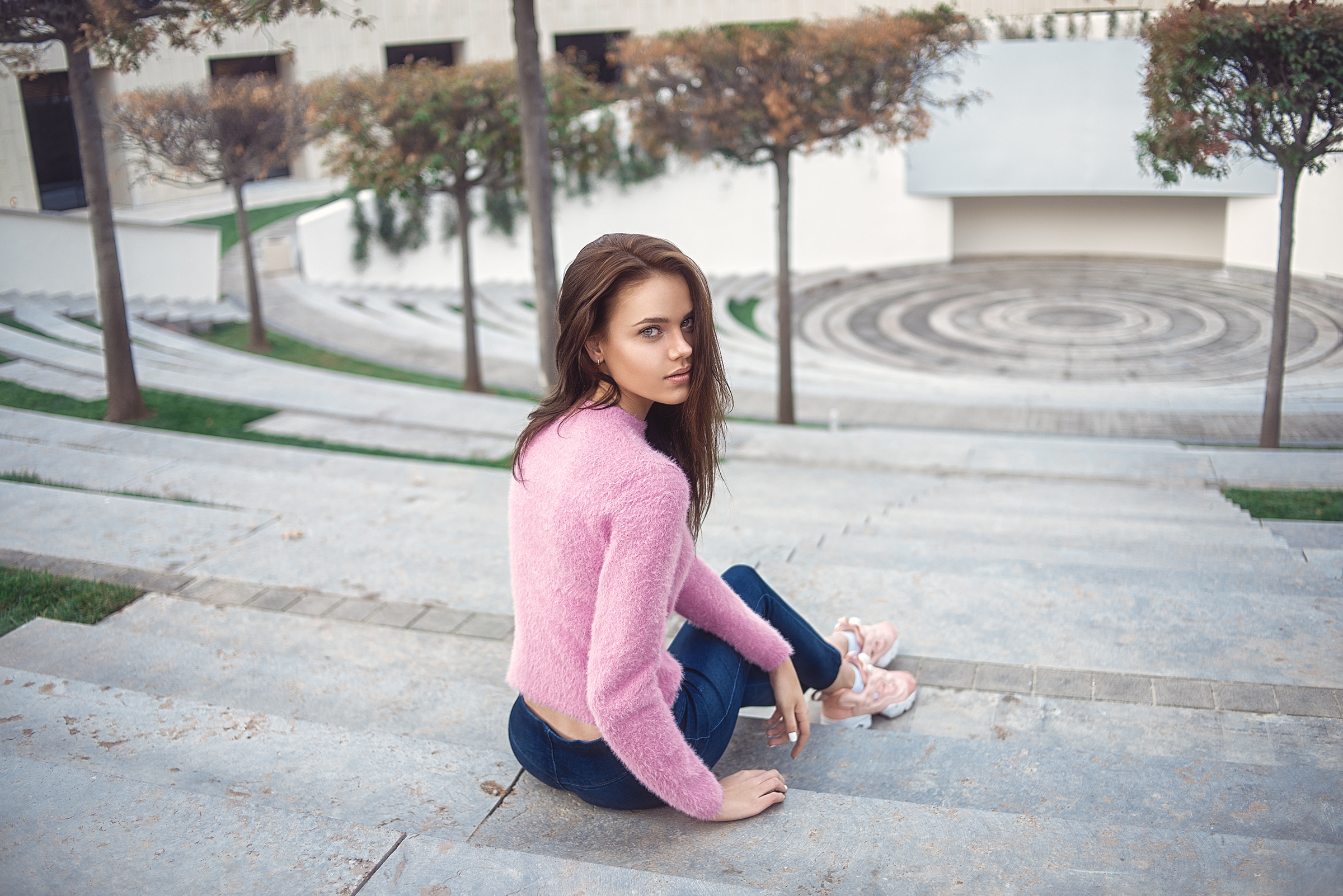Woman in pink sweater sitting on stairs outdoors HD Wallpaper