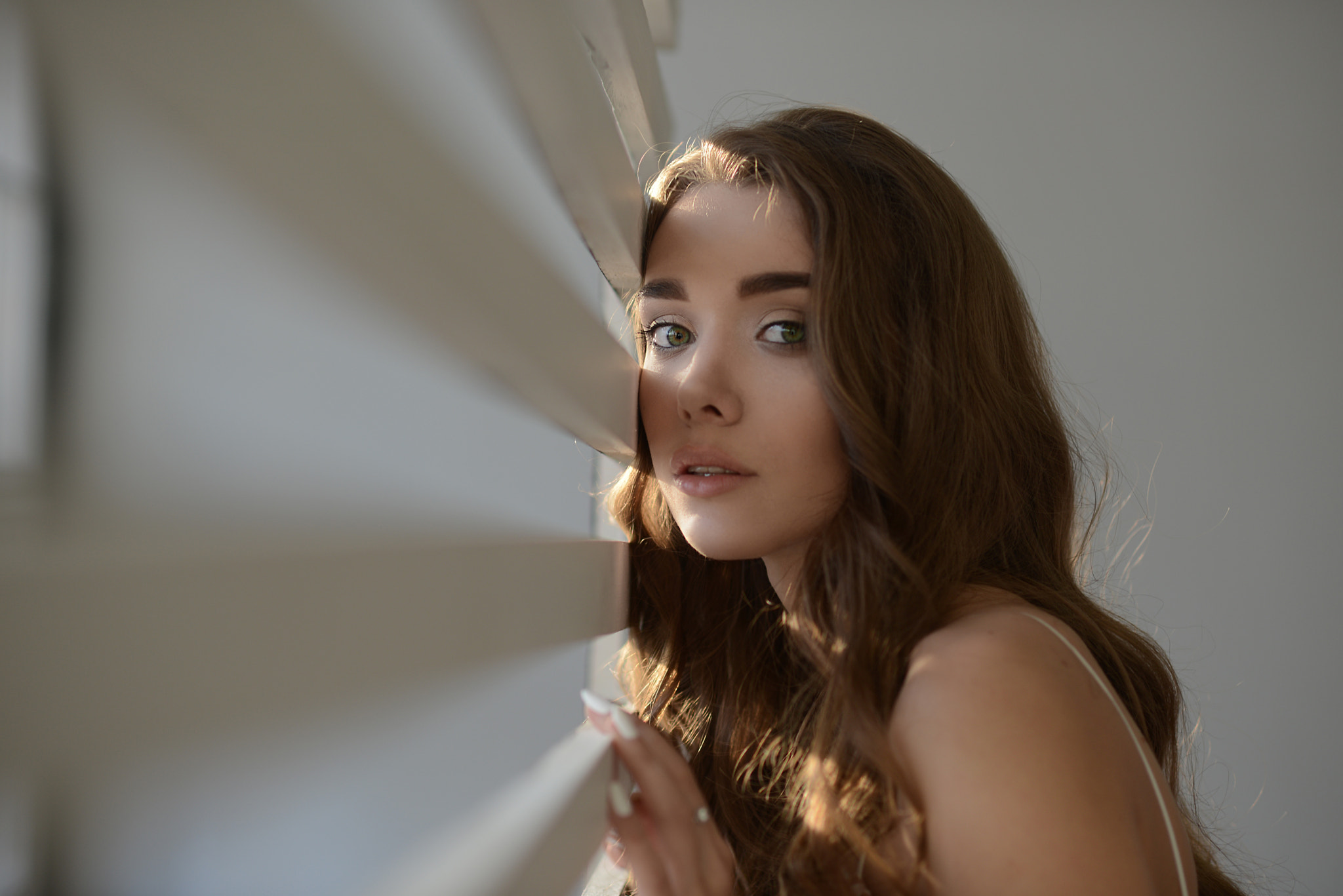 Woman with long brown hair peeking through blinds HD Wallpaper