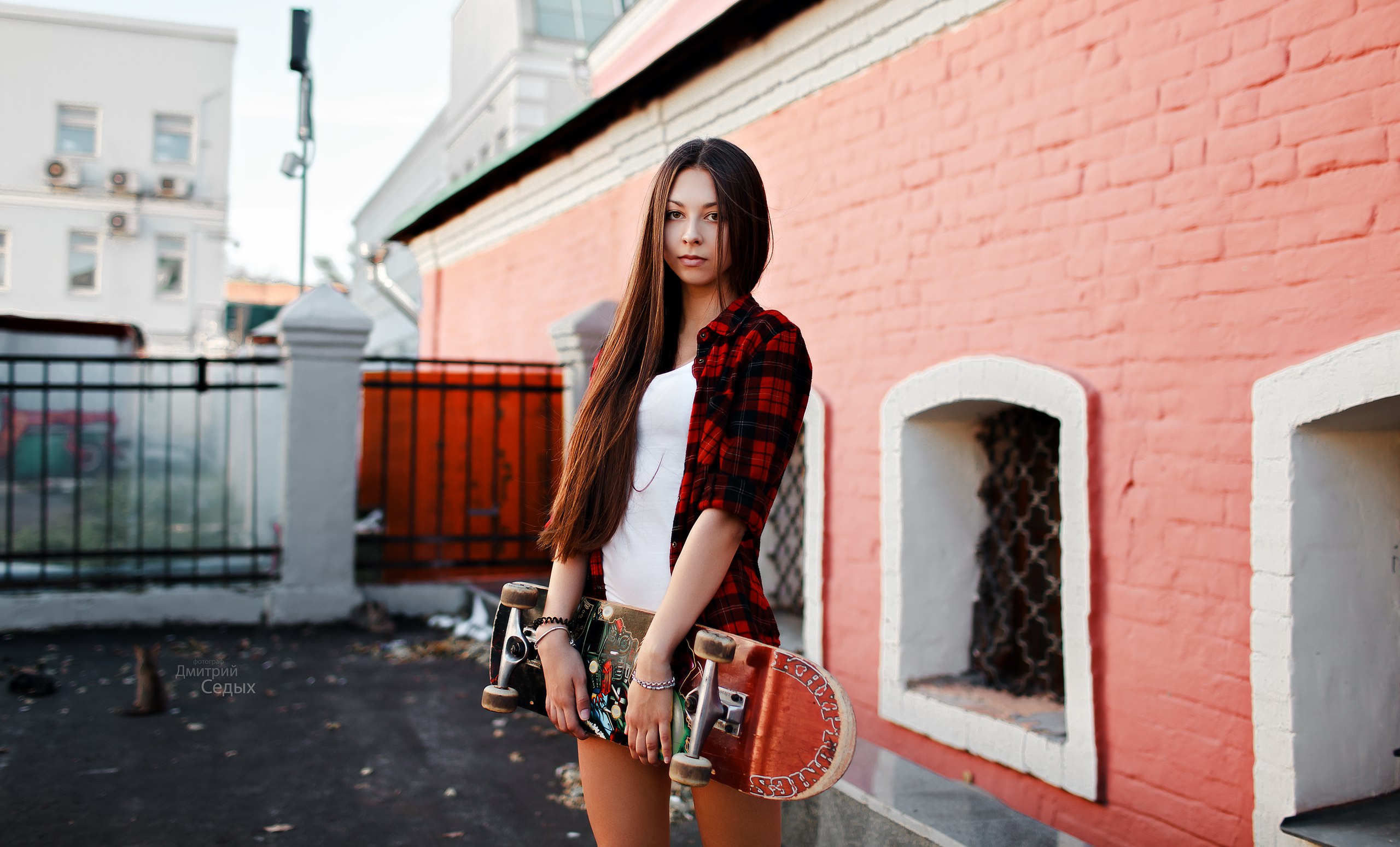 Woman with long hair holding a skateboard outdoors HD Wallpaper