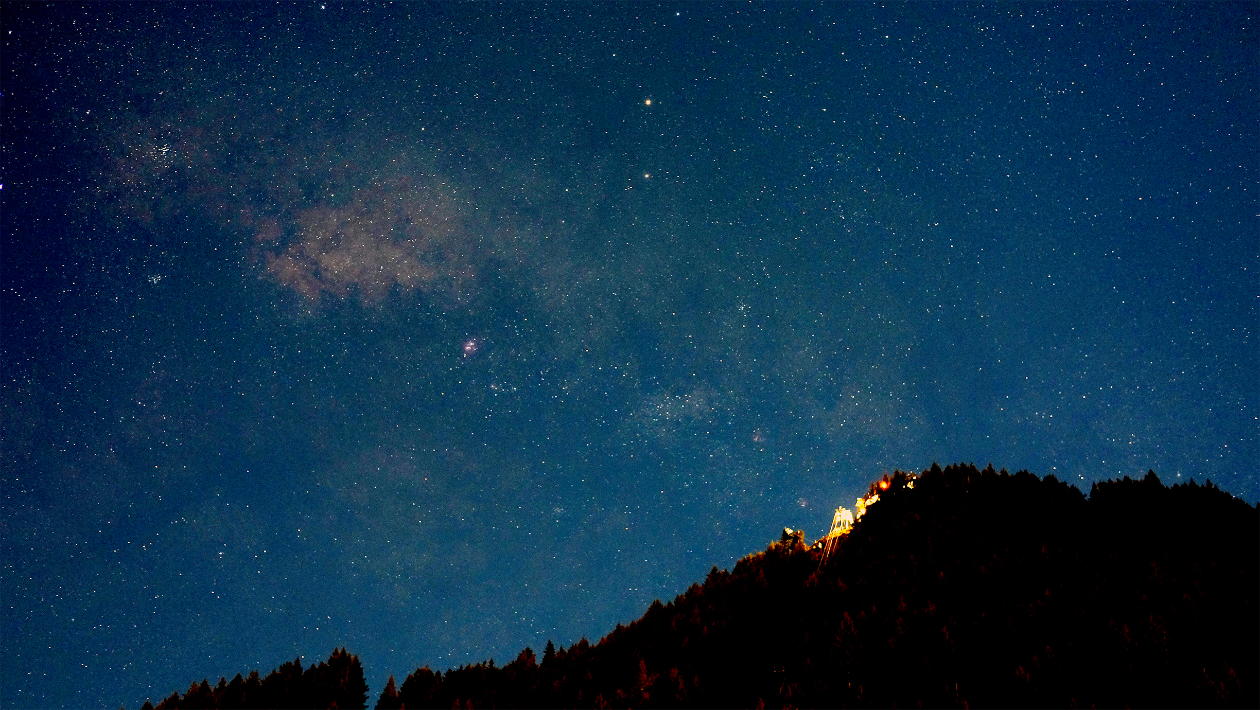 Starry night sky over a mountain forest HD Wallpaper