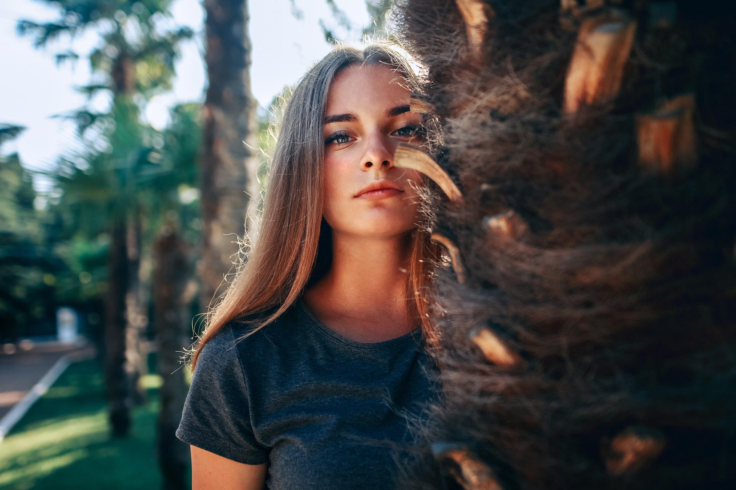Portrait of a young woman outdoors near a palm tree HD Wallpaper
