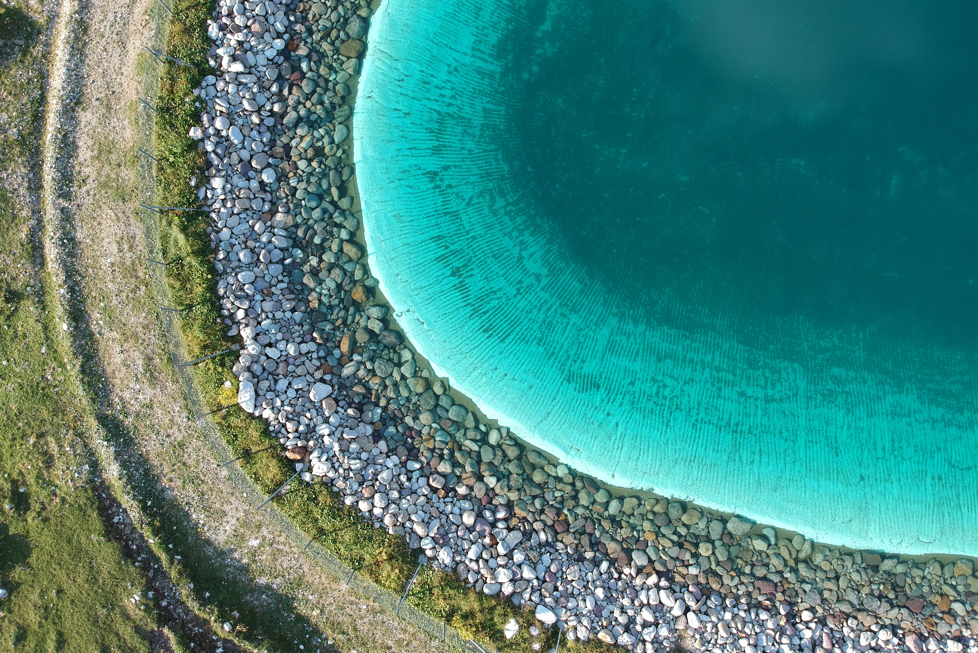 Aerial view of a rocky shore meeting turquoise water HD Wallpaper
