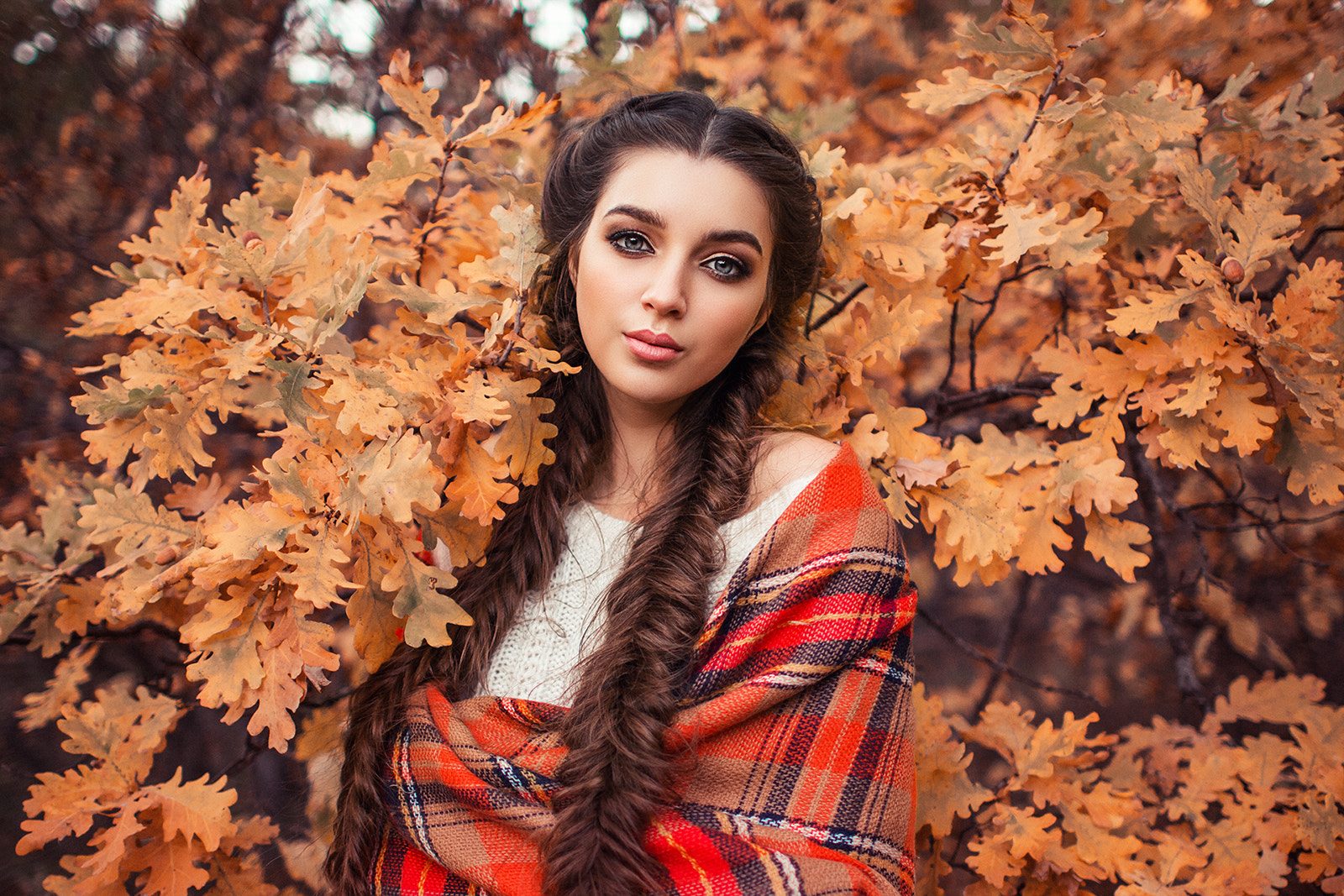 Woman with braids wrapped in a plaid blanket outdoors HD Wallpaper