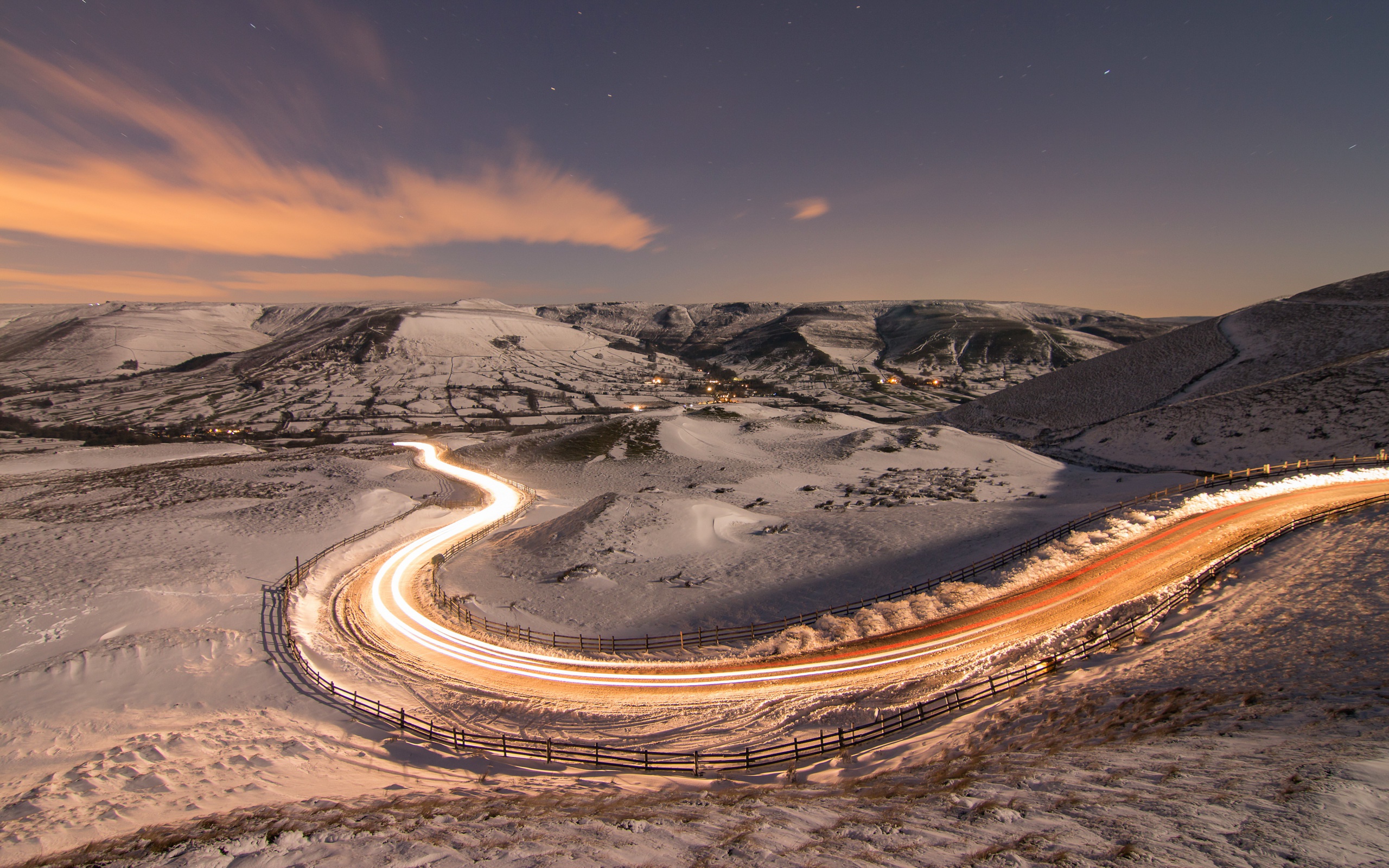 Long exposure road through snowy landscape at night HD Wallpaper