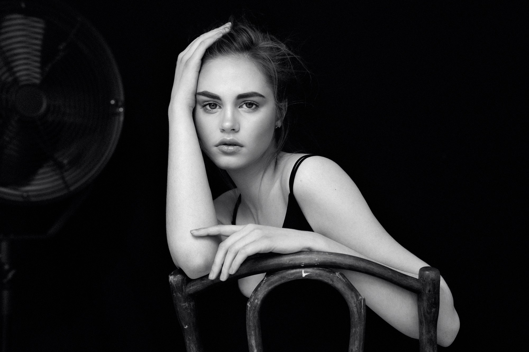 Woman sitting on a chair in front of a fan HD Wallpaper