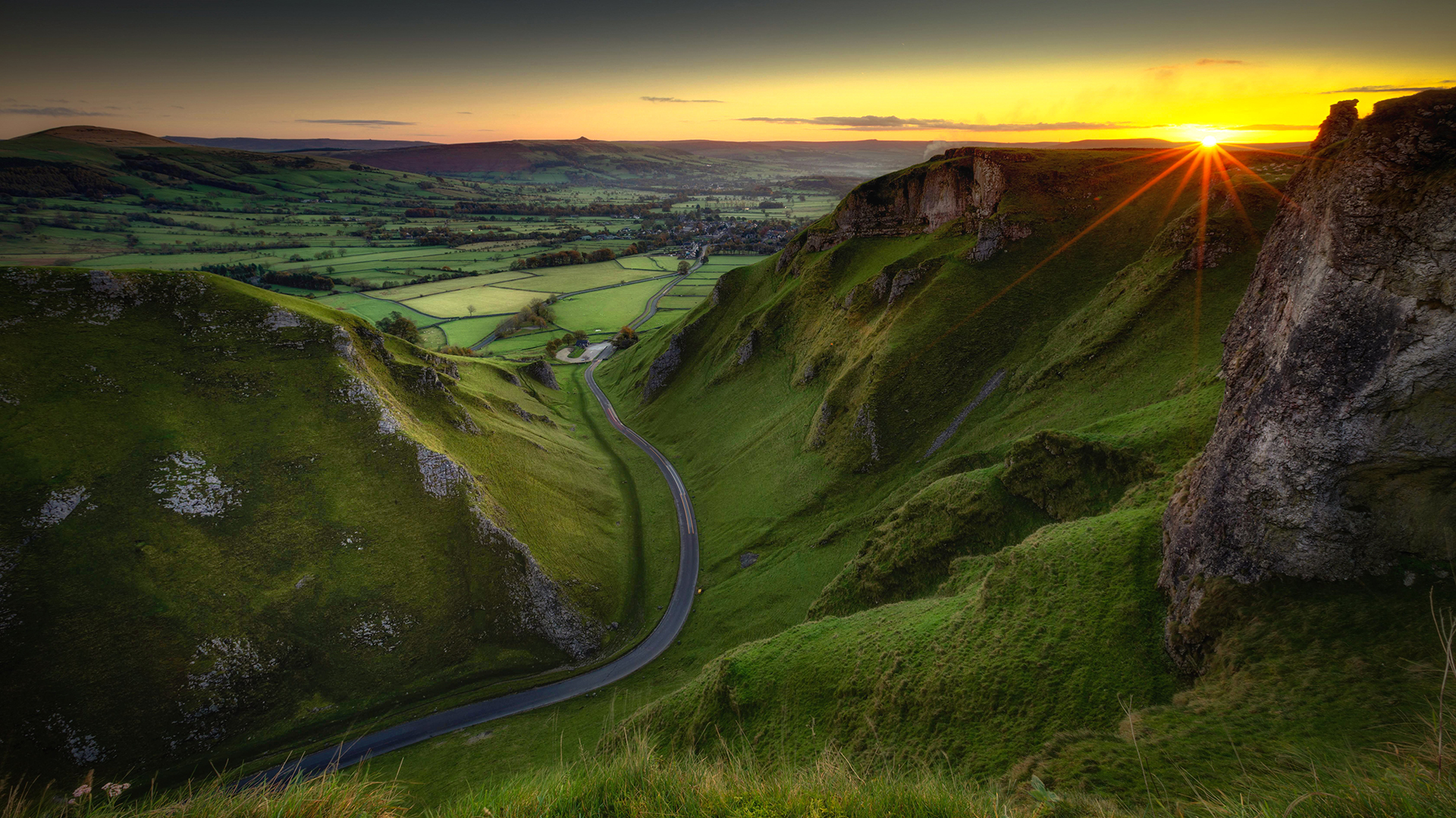 Scenic valley road at sunset with rolling hills HD Wallpaper