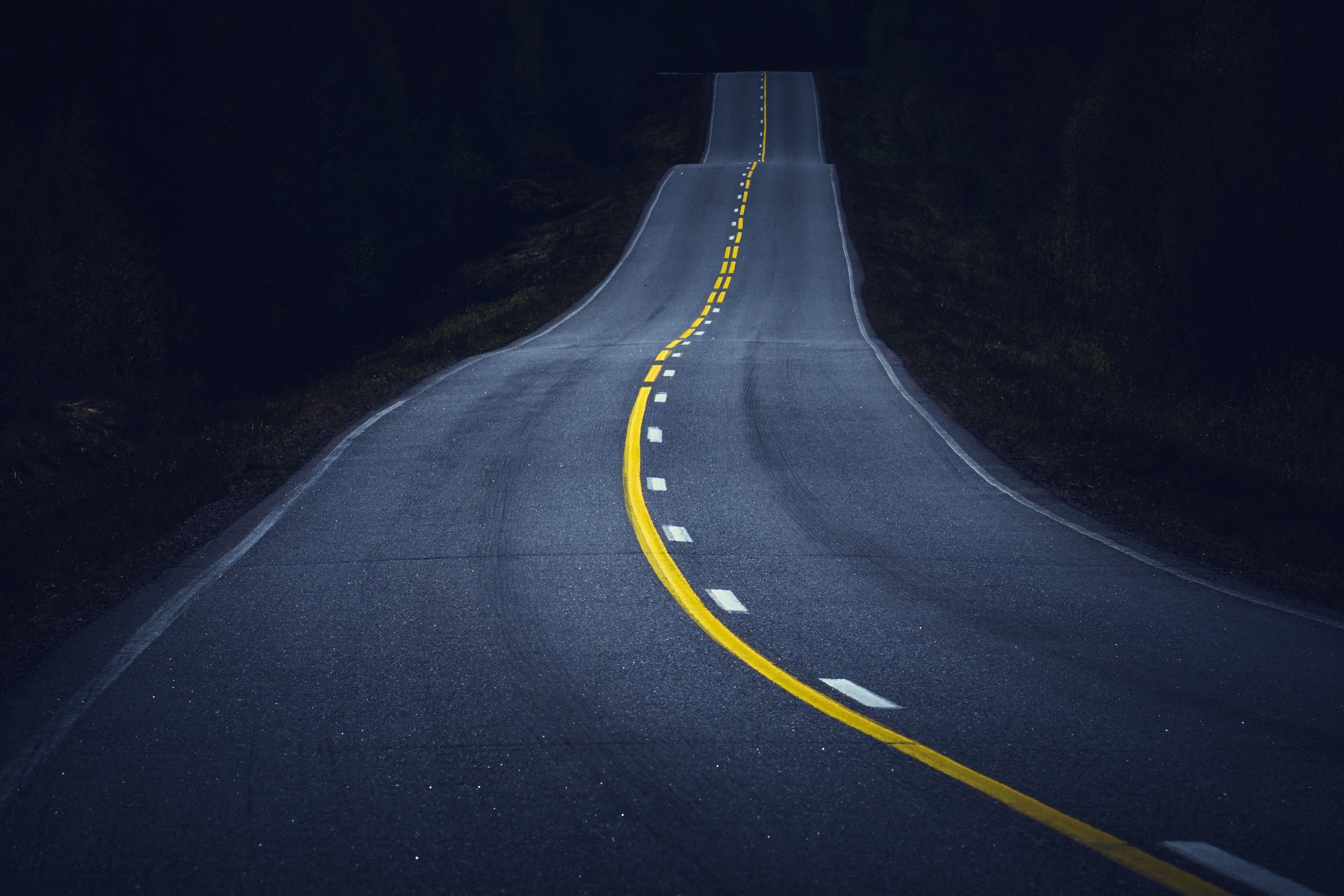 A winding asphalt road at night HD Wallpaper