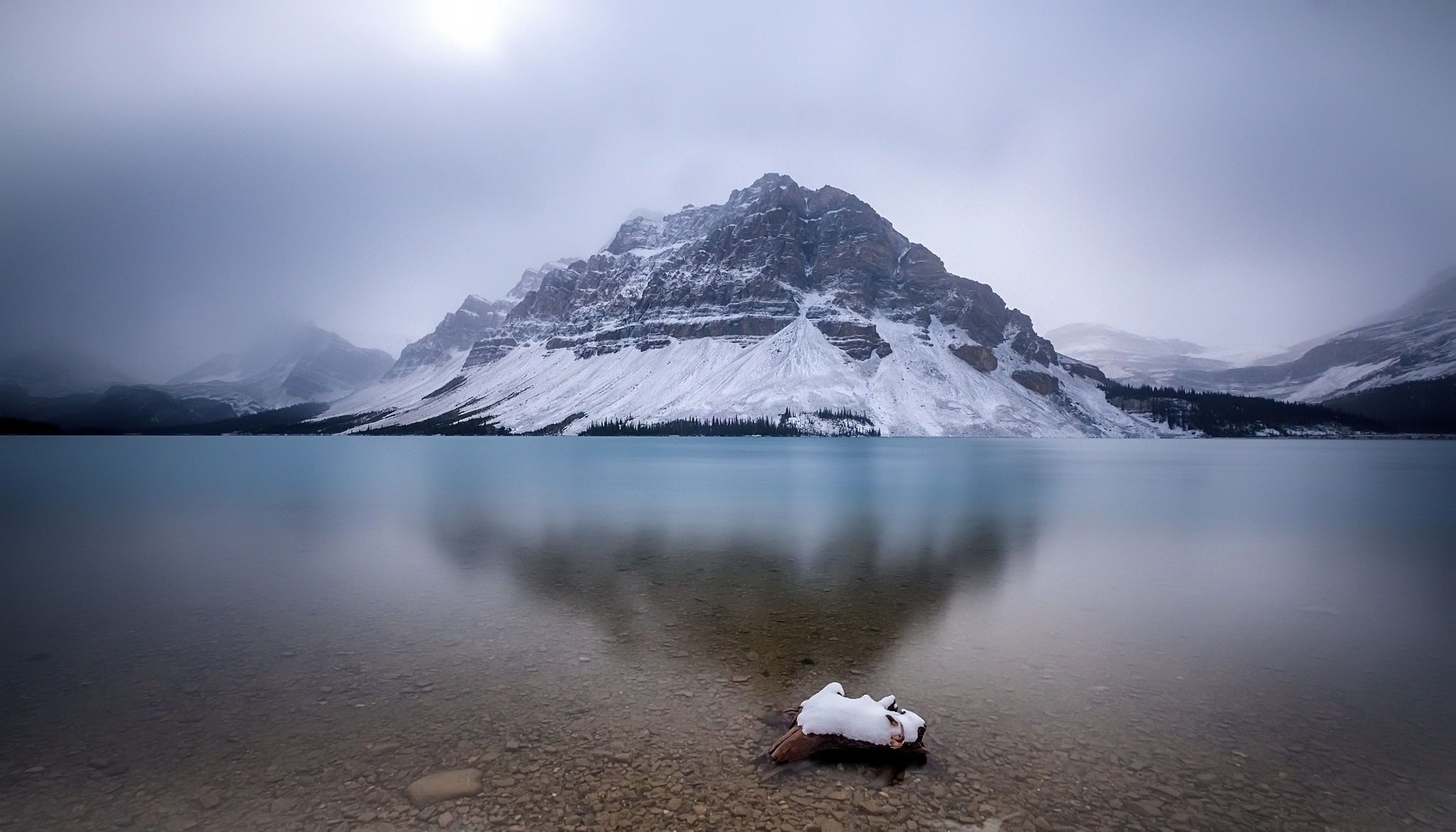 Snow-covered mountains reflected in a calm lake HD Wallpaper