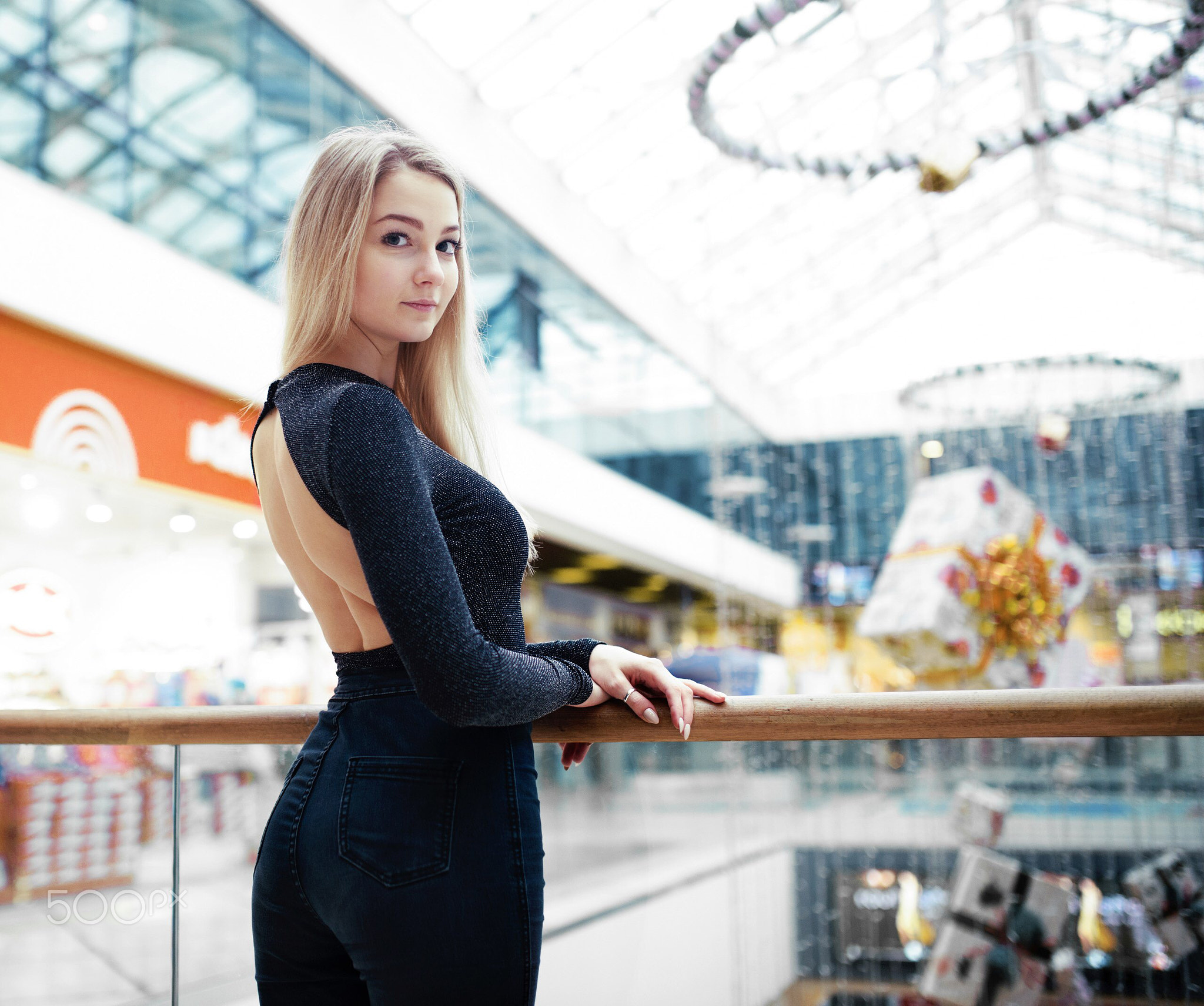 Woman in a dark top and jeans in a mall HD Wallpaper
