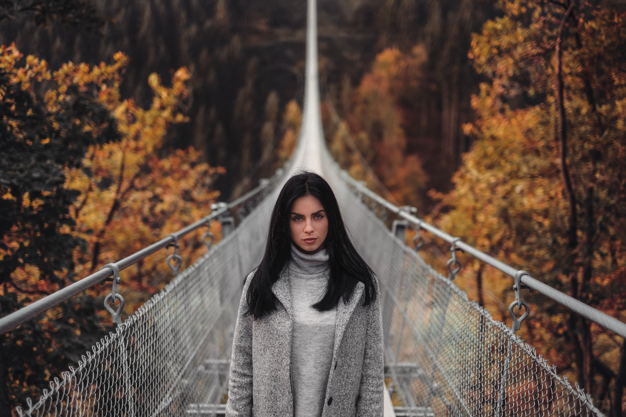 Woman on a suspension bridge in autumn HD Wallpaper
