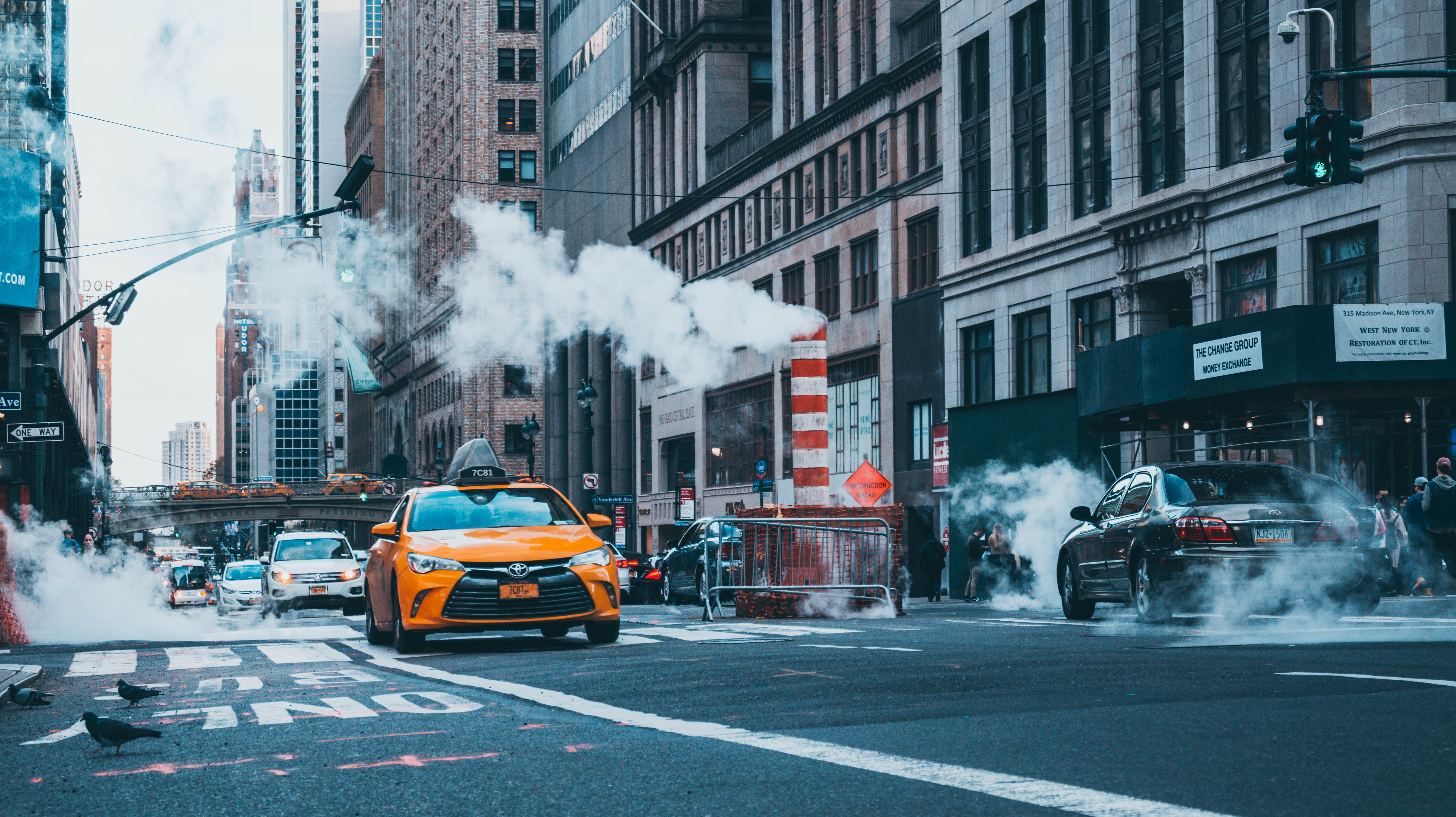 Yellow taxi and cars on a New York City street with steam HD Wallpaper