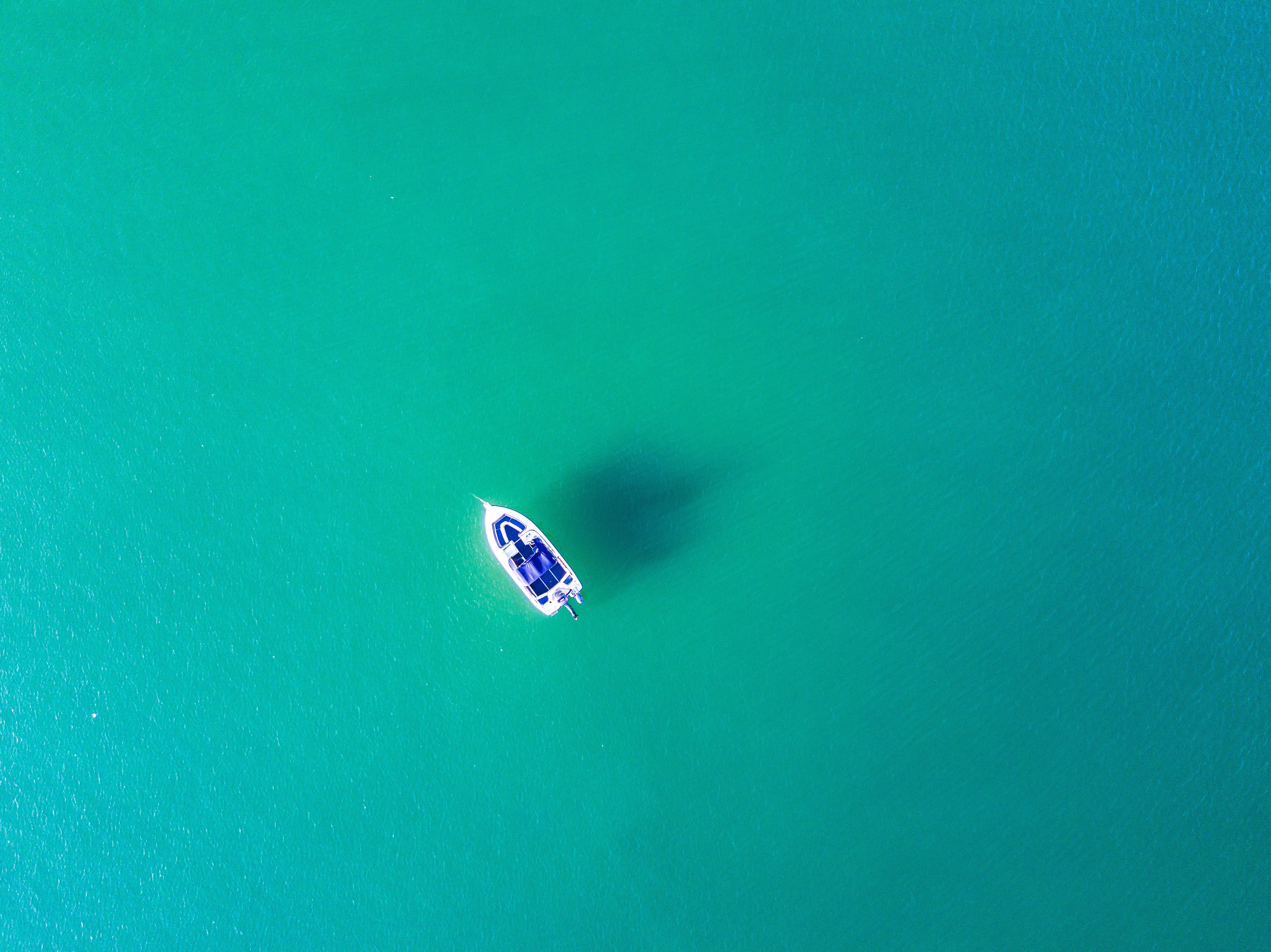 Aerial view of a white boat on turquoise water HD Wallpaper