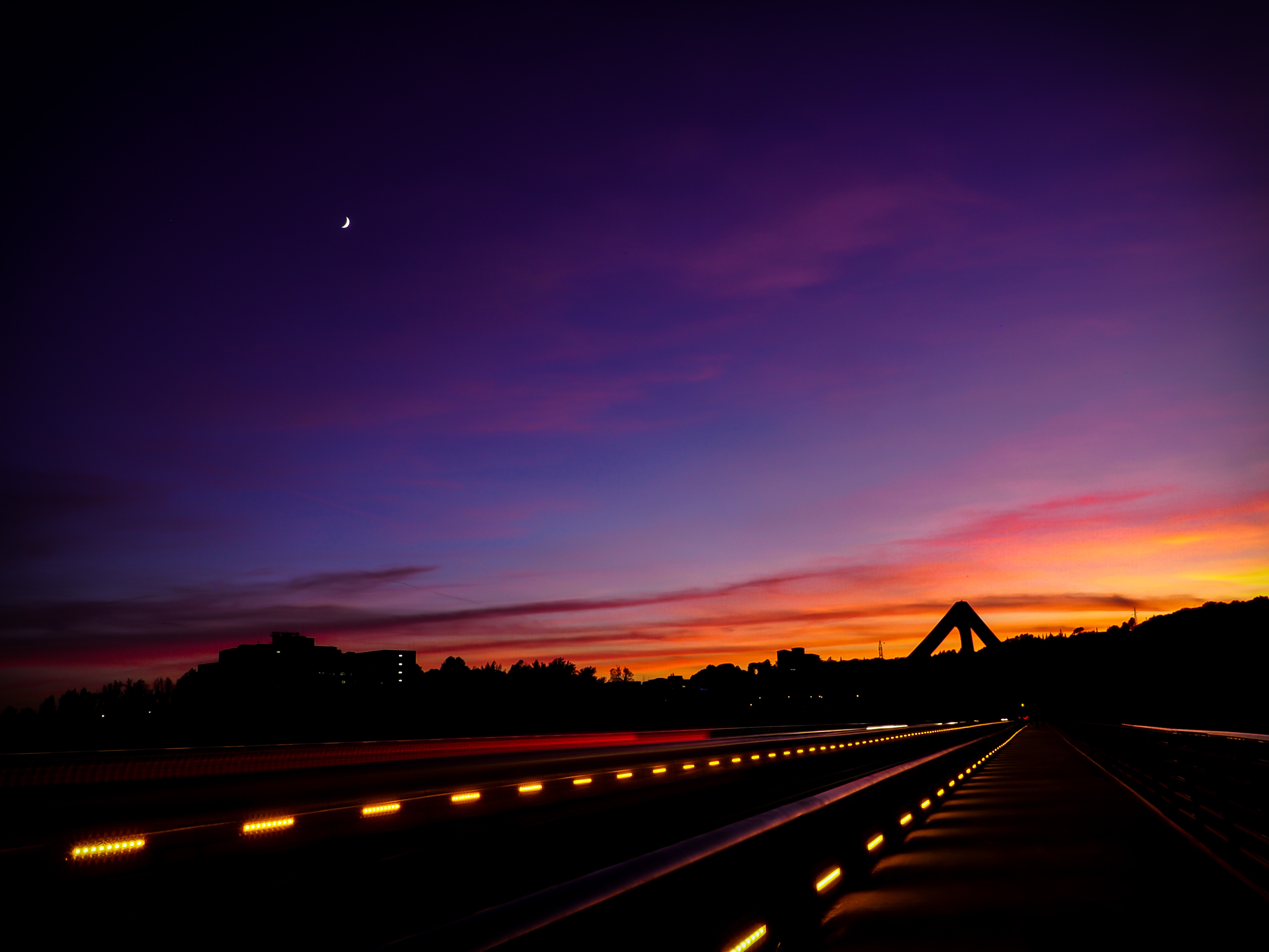 Sunset over a road with lights and a crescent moon HD Wallpaper