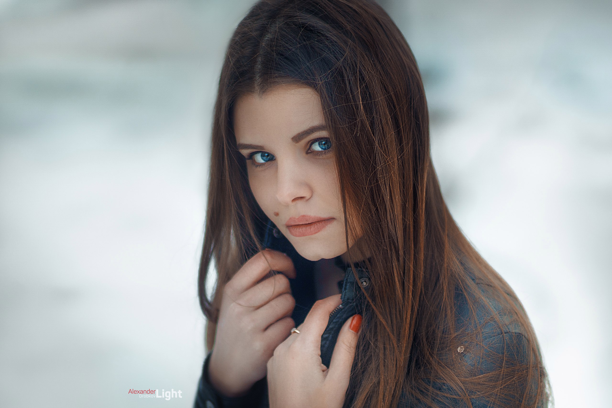 Woman with blue eyes and long brown hair in leather jacket HD Wallpaper