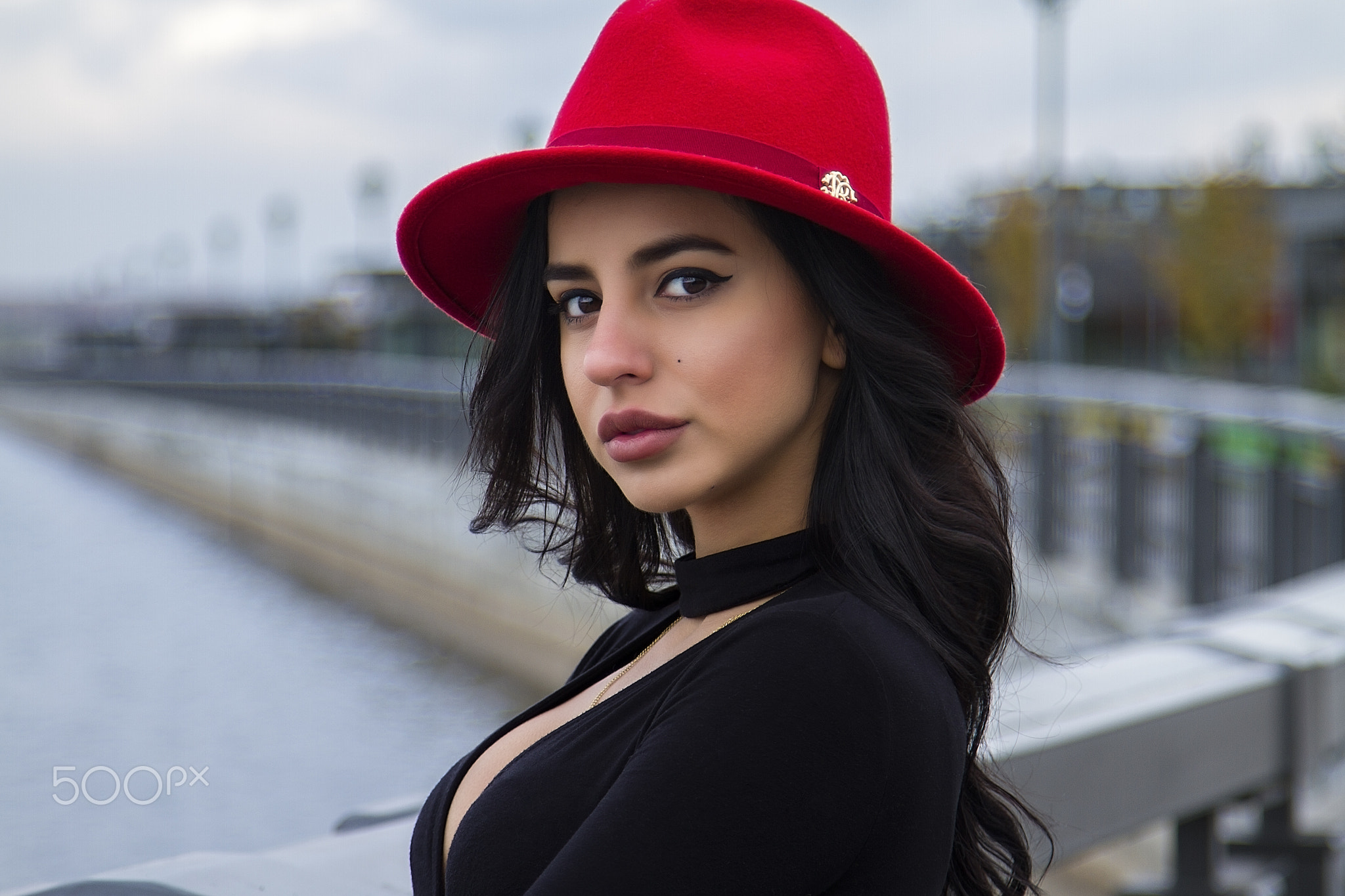 Woman in red hat and black top outdoors HD Wallpaper