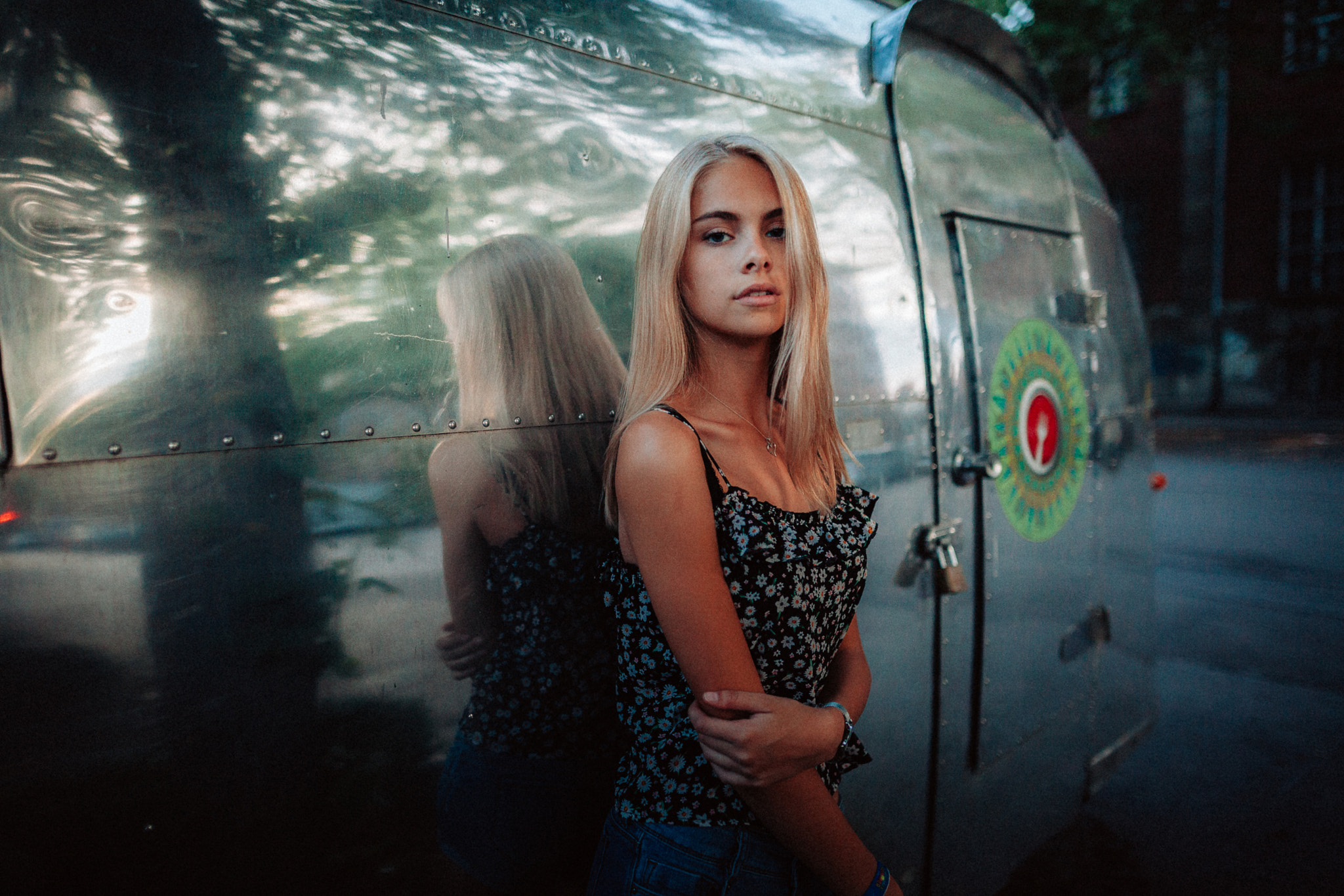 Woman leaning against a shiny Airstream trailer HD Wallpaper