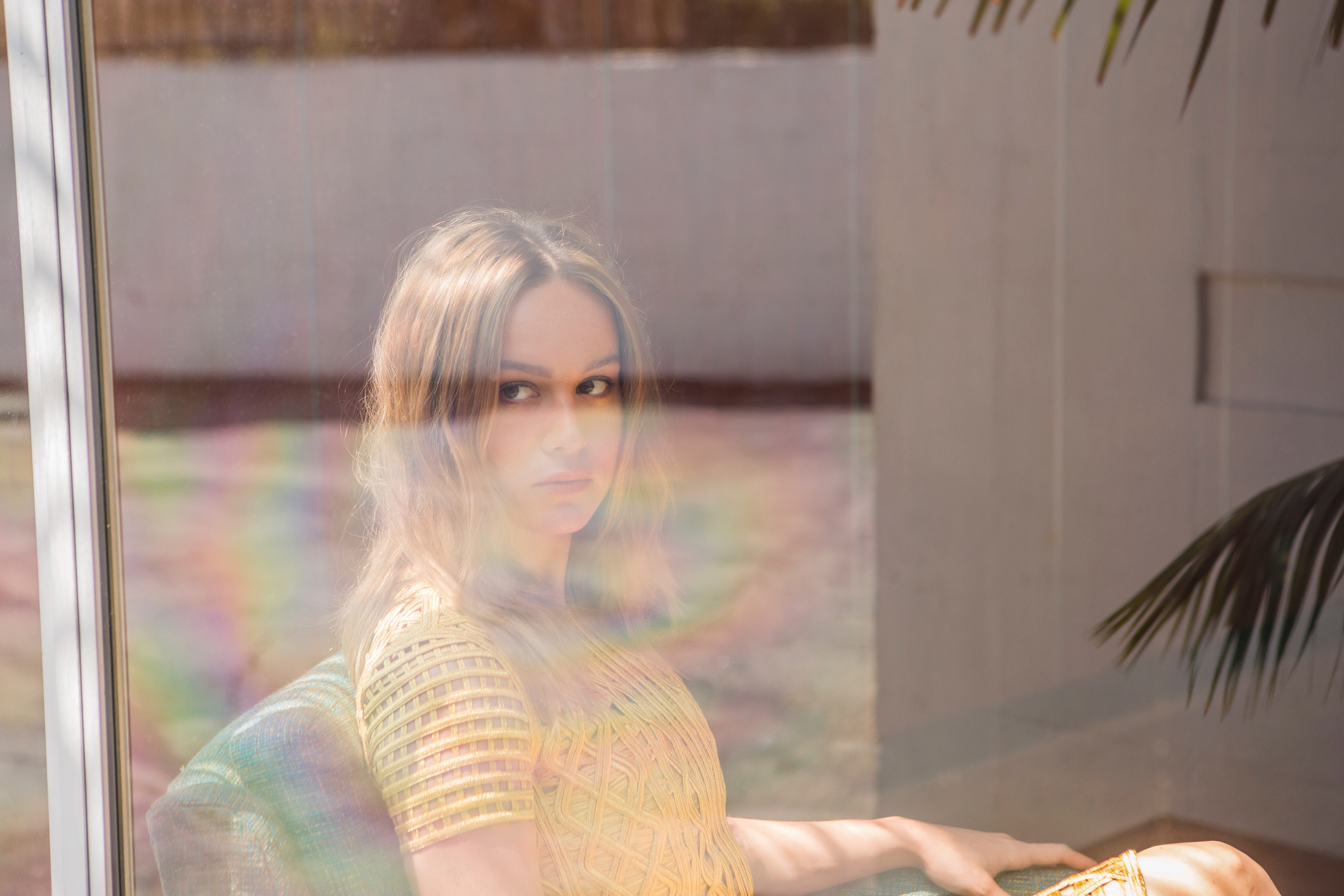 Brie Larson sitting by a window HD Wallpaper