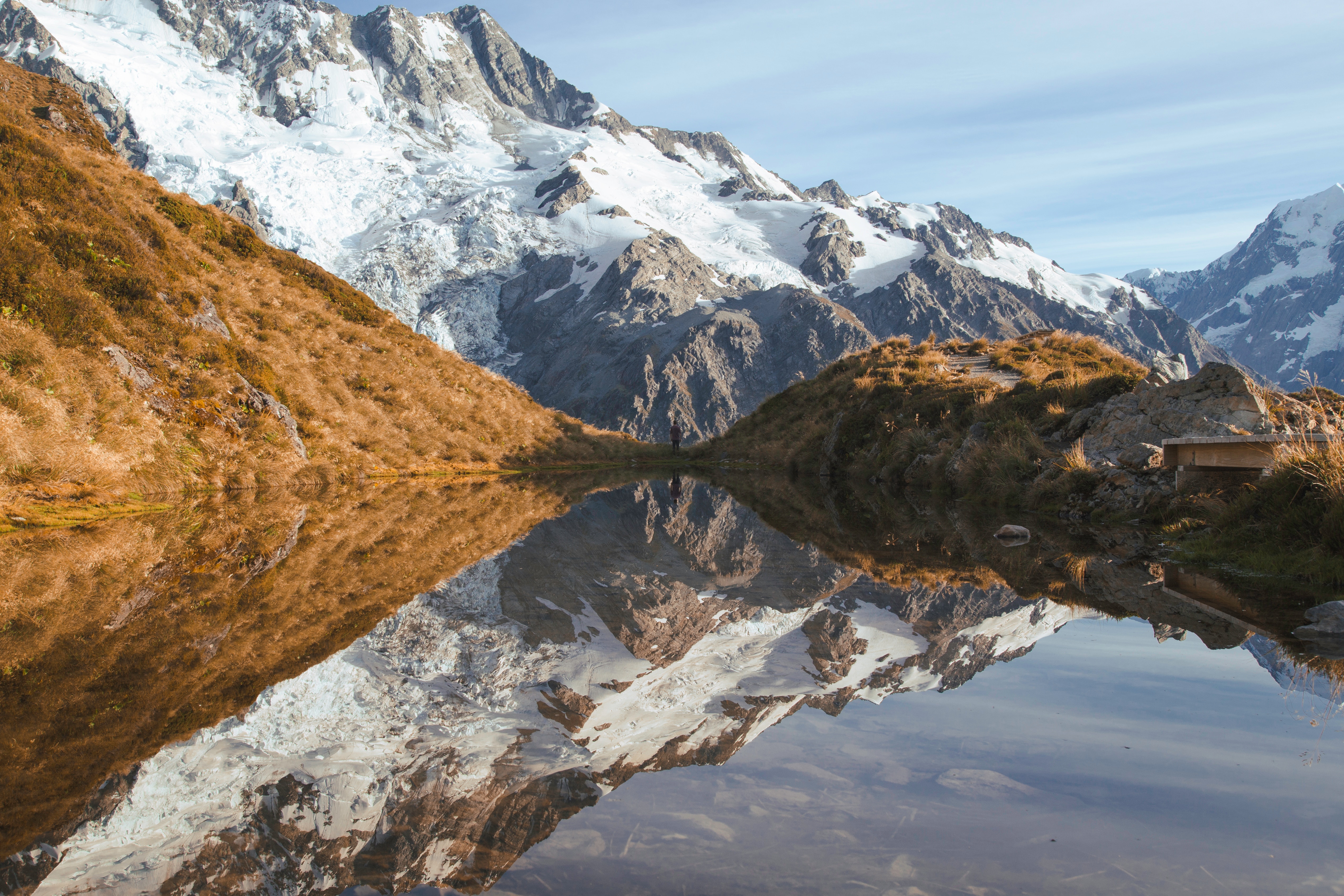 Snow-capped mountains reflected in a calm lake HD Wallpaper